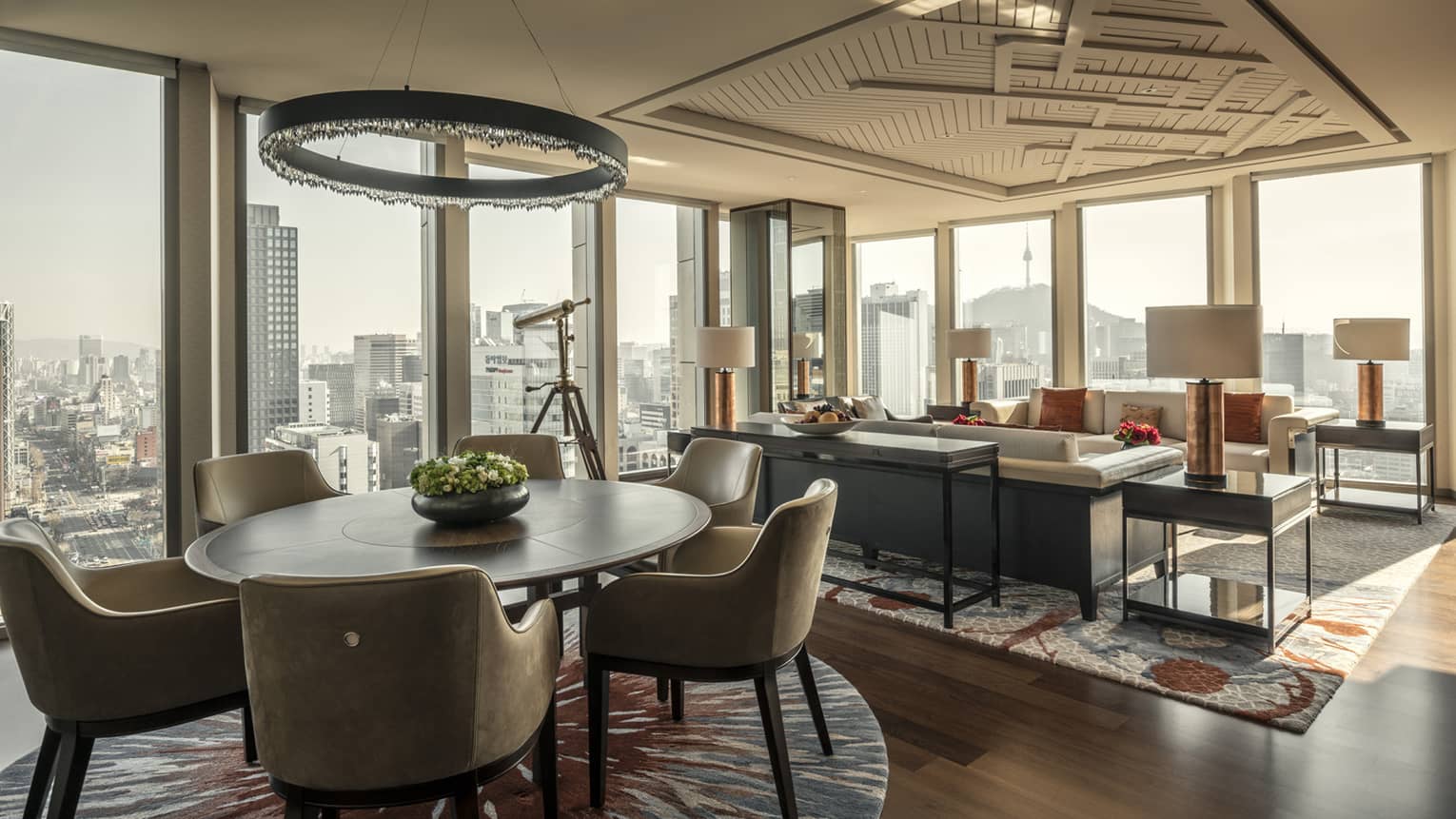 Sejong Two-Bedroom Suite round dining table under modern chandelier, seating area, corner windows