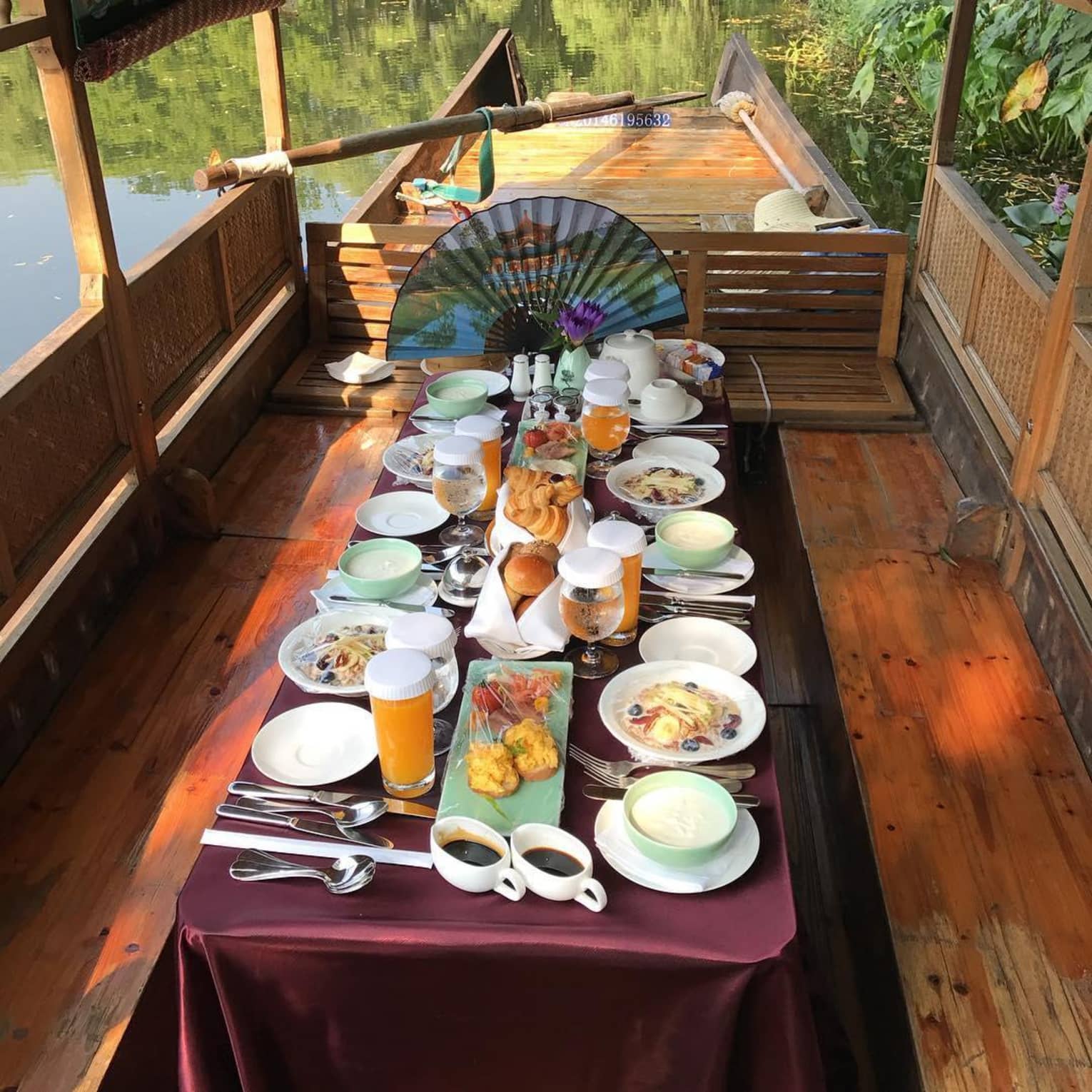 Long private dining table with purple satin linens, coffee, brunch items, pastries