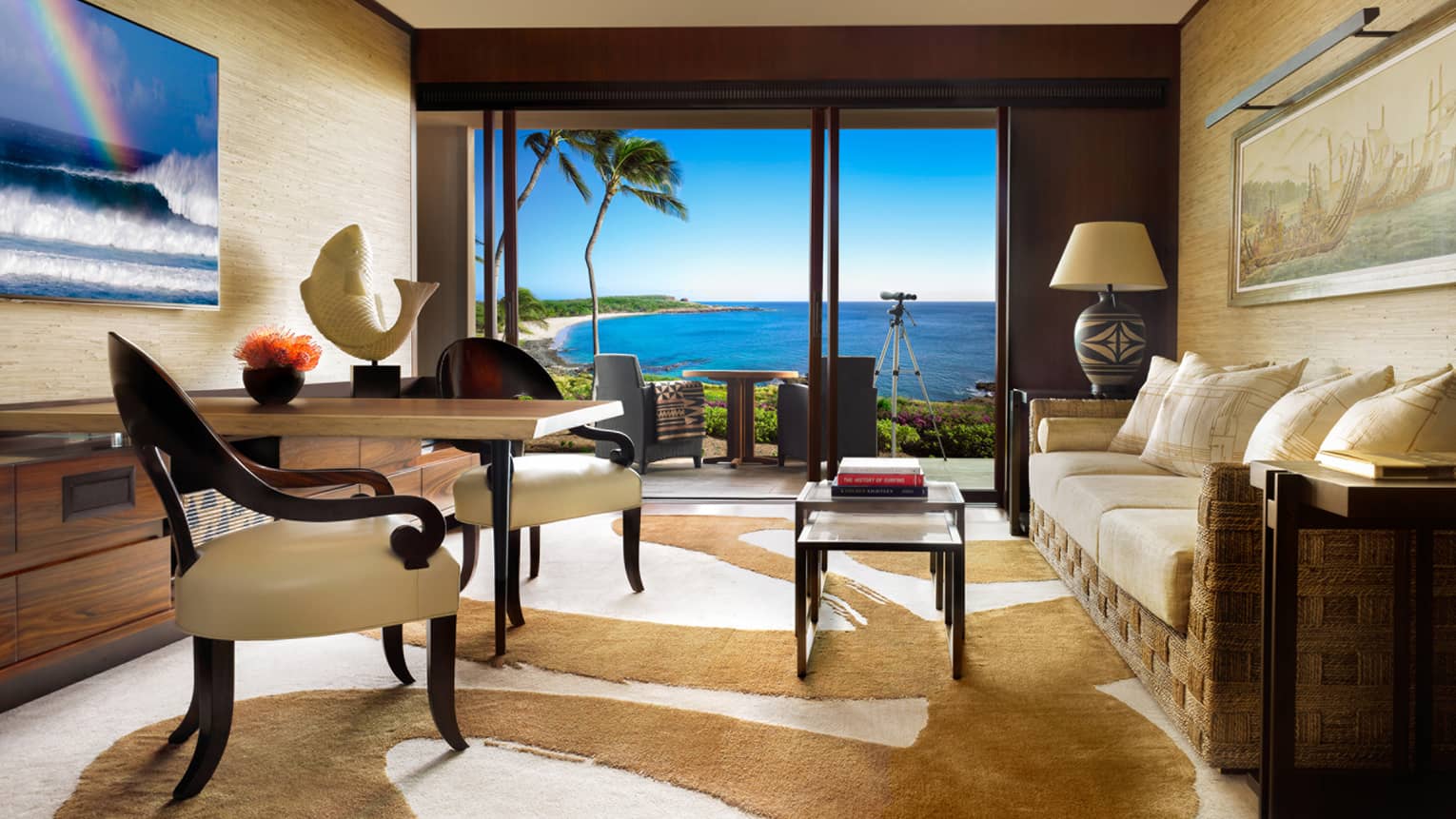 Ocean view suite with wood-and-white dining chairs, table with white fish statue, brown-and-white rug, rattan sofa
