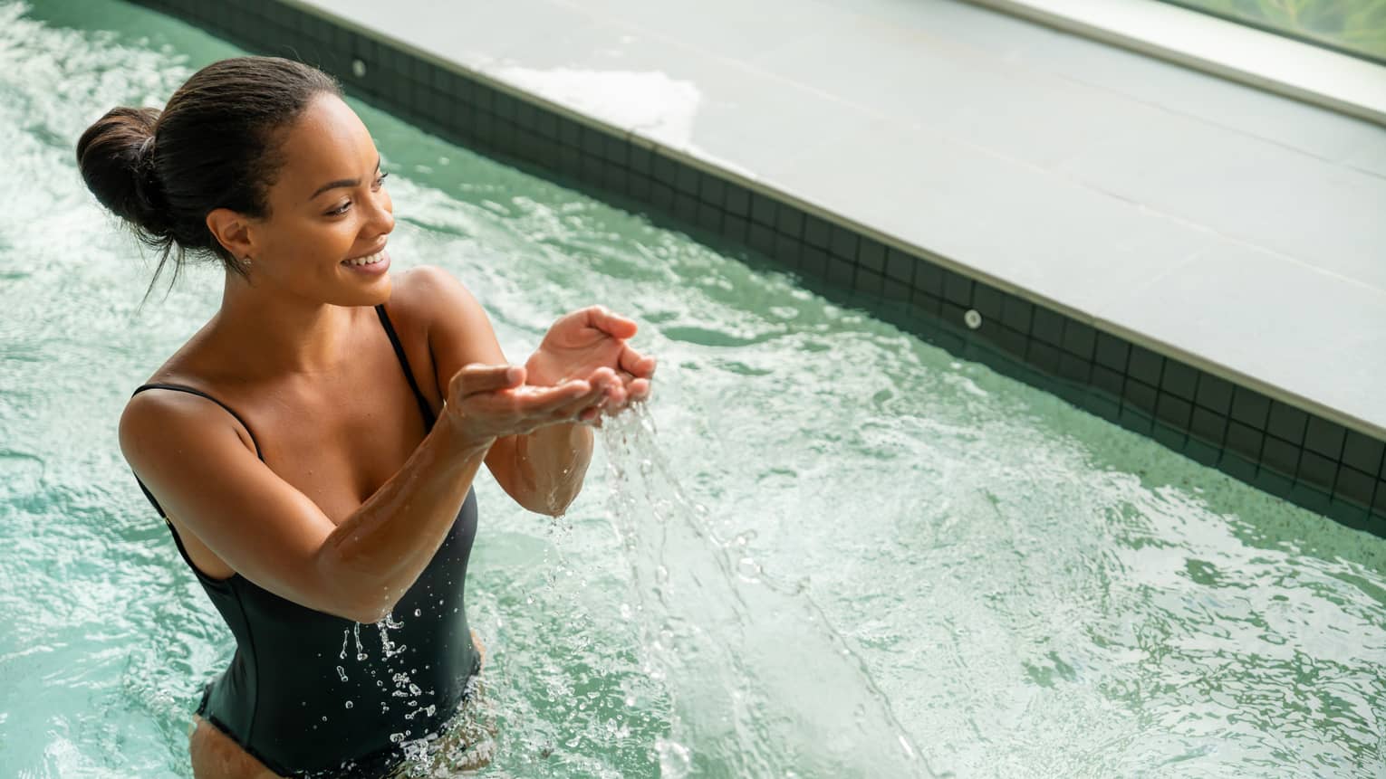 Guest wearing a swimsuit and splashing water in the pool.