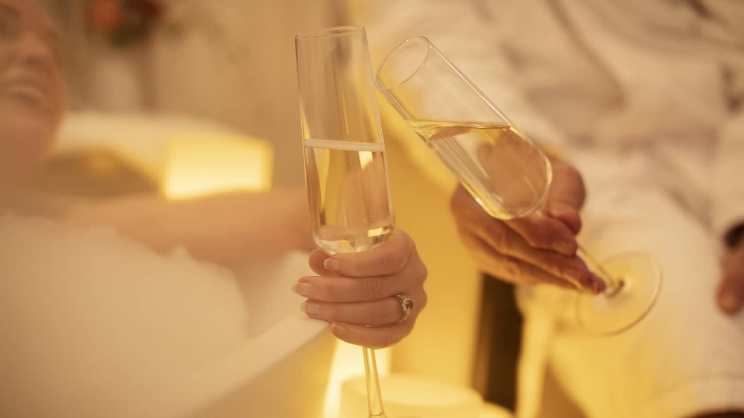 Two guests holding wine glasses and clinking their wine glasses.