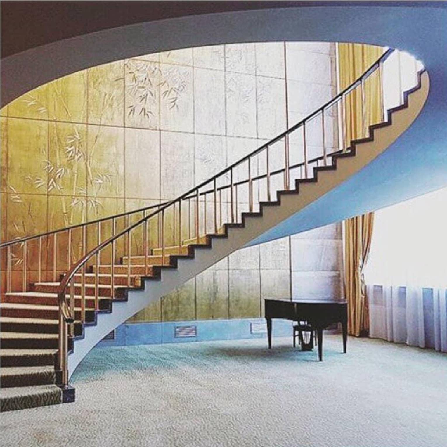 Modern curved staircase with wood ceiling and tile walls