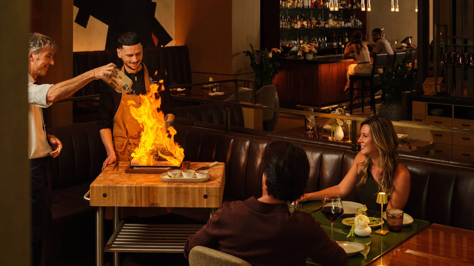 Two chefs cooking a guest?s food tableside at a restaurant