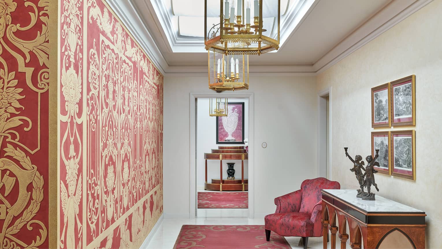 Luxury hotel suite entryway, featuring rich red and gold wallpaper
