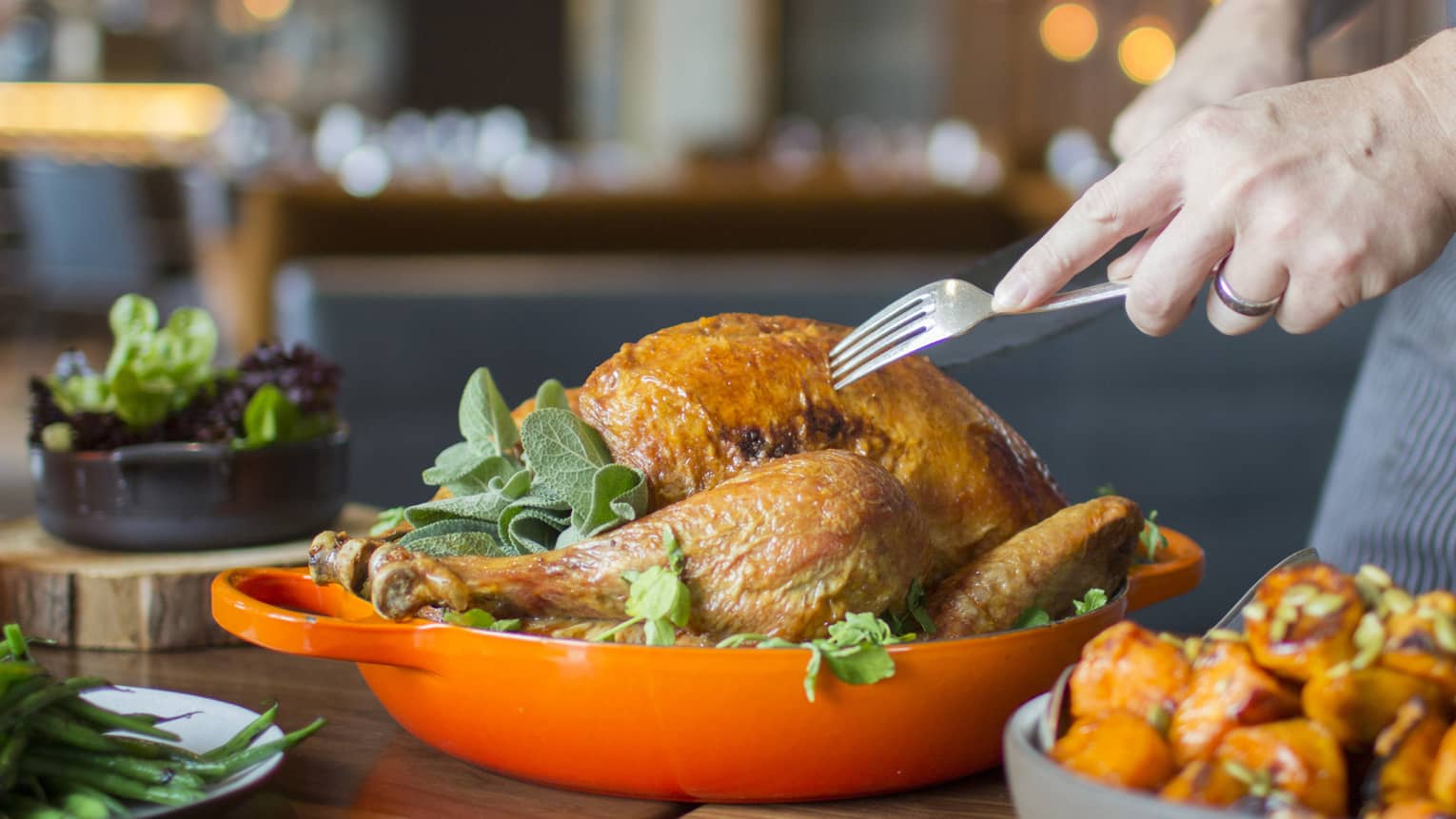 Thanksgiving turkey in orange dish being served by server holding fork