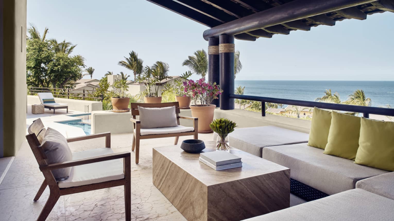 Covered, ocean-view outdoor lounge with sectional sofa and two chairs