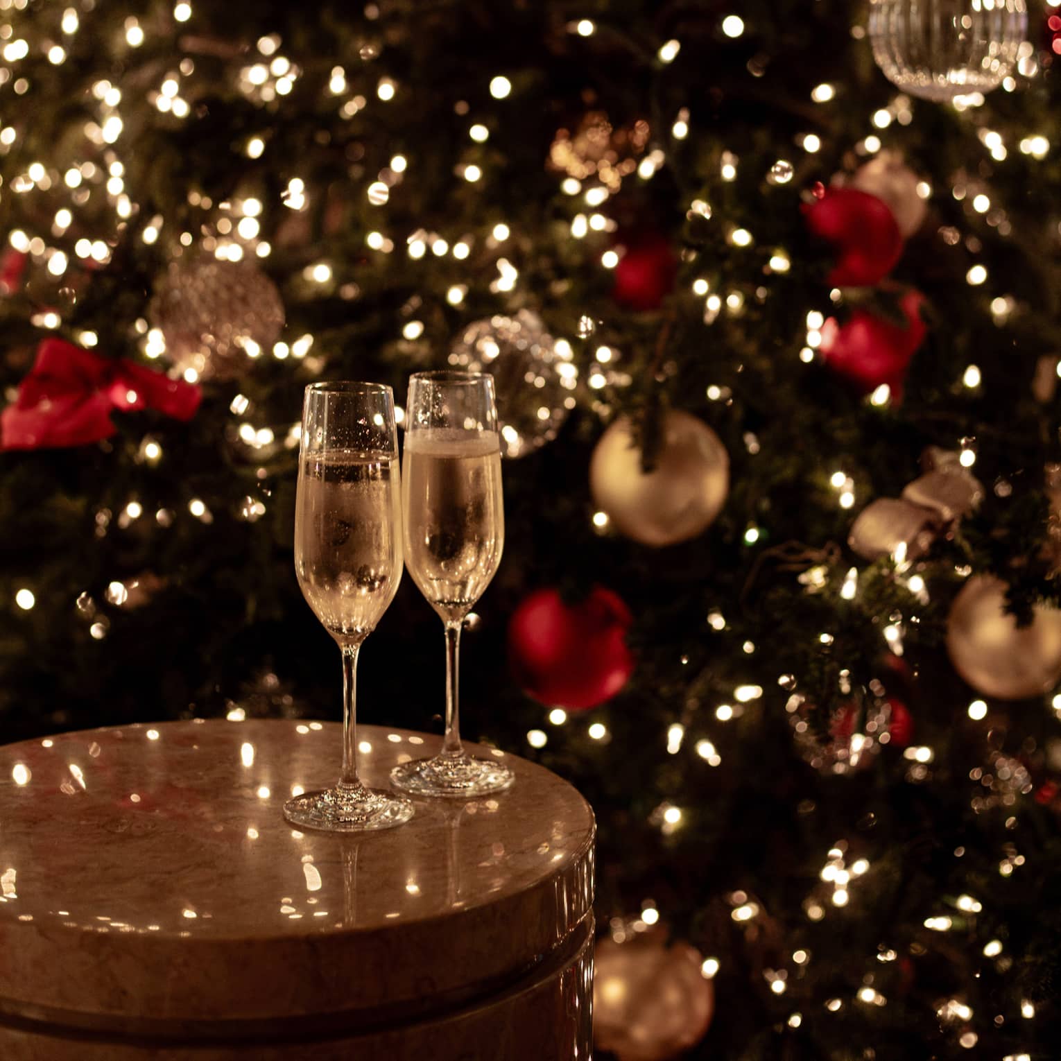 Joyous champagne toast with festive lights for Tokyo Christmas and New Year’s Eve celebrations.