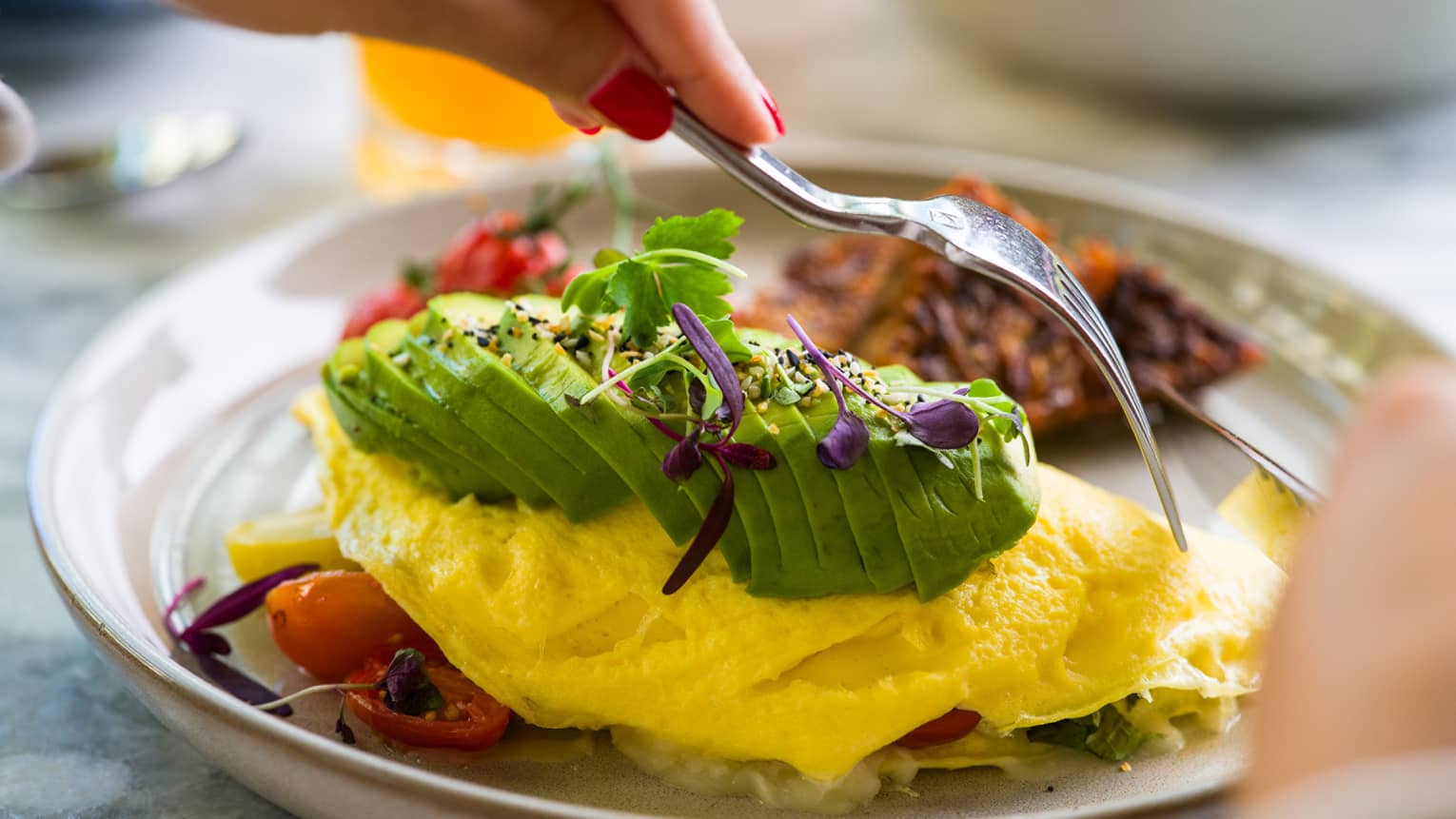 Scrambled eggs on a plate topped with avocado slices