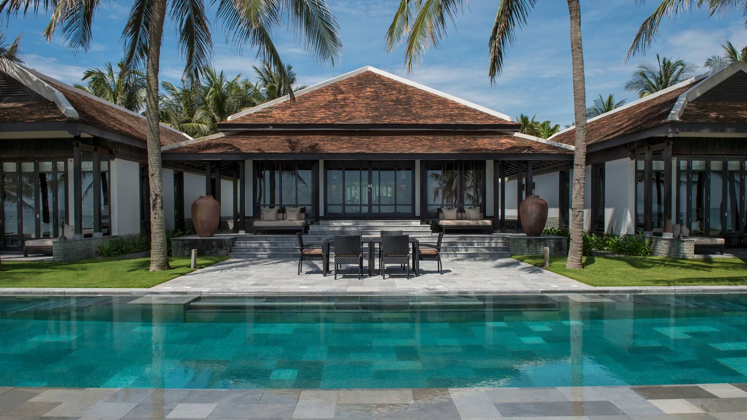 View of Ocean View Pool Villa exterior, patio under palms, from outdoor pool