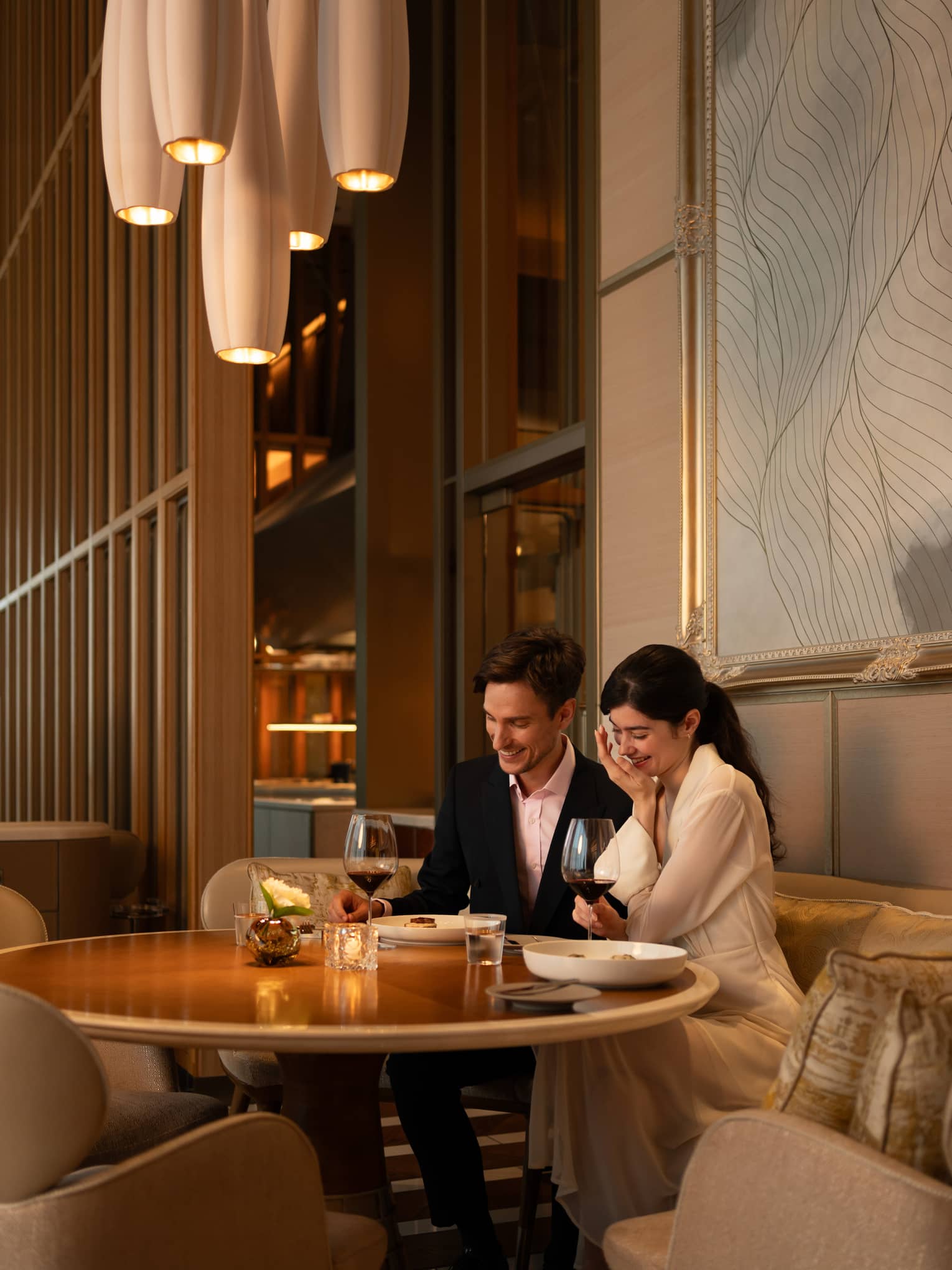 A couple enjoys a romantic dinner at est, a French restaurant in Tokyo, savoring fine wine and cuisine.