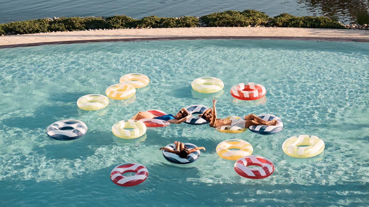 Guests floating on floats in a pool.