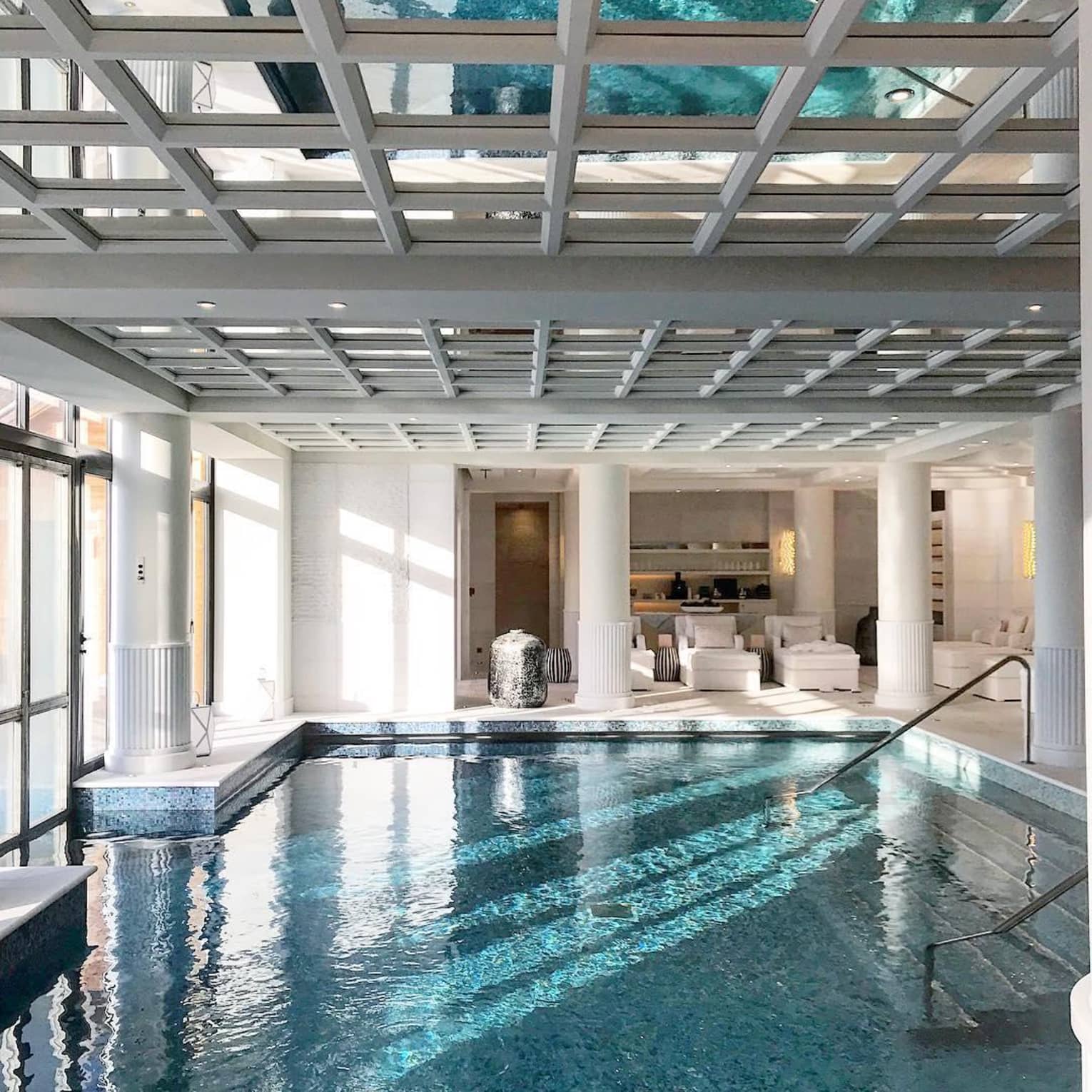 Indoor swimming pool under white beam ceiling, pillars