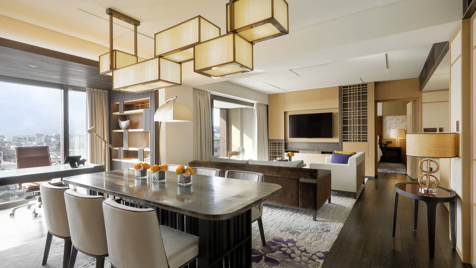 A luxury hotel residence dining and living area with modern lighting fixture over the dining table set for six