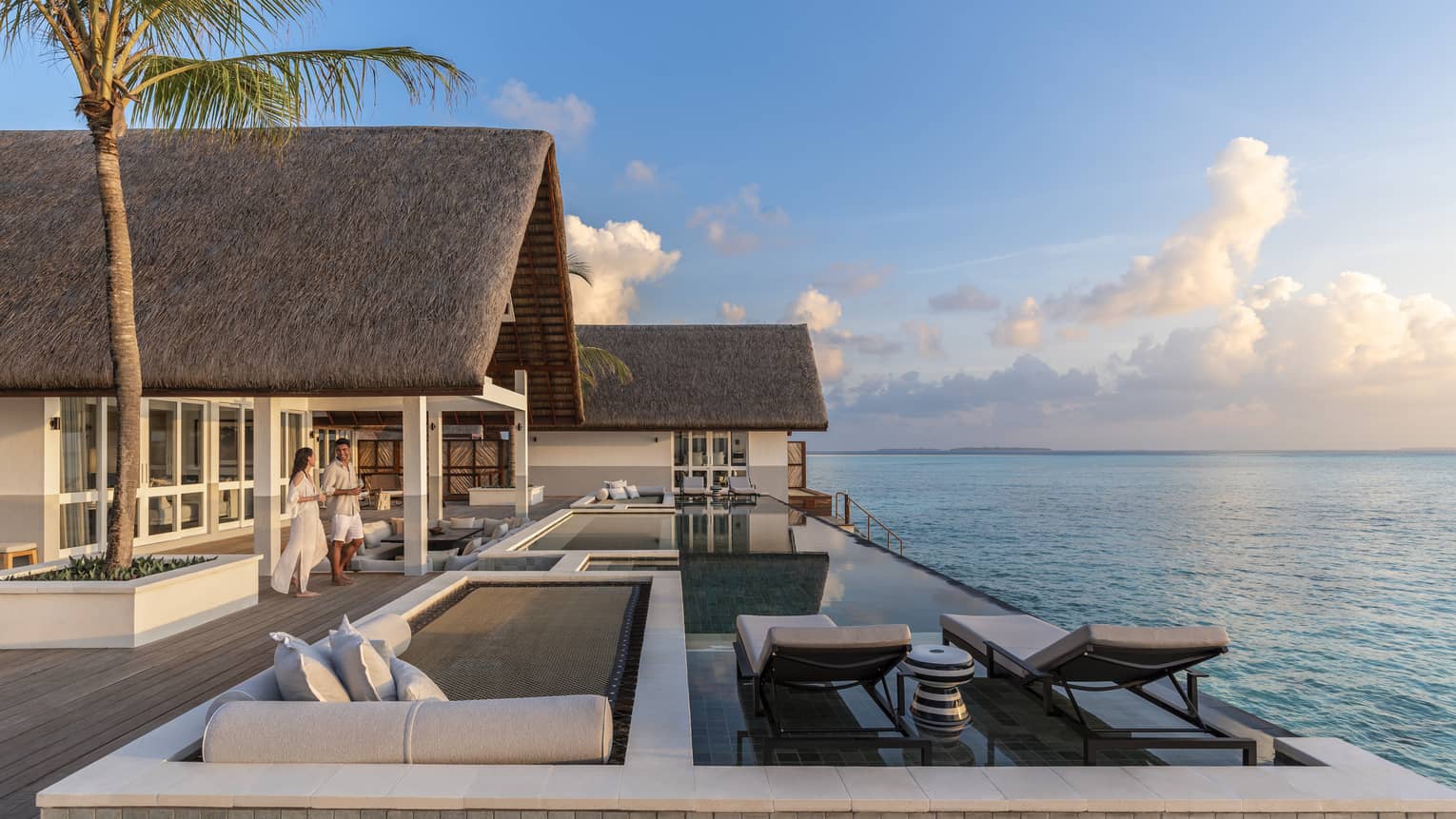 Couple walk out to large patio of Three Bedroom Water Suite