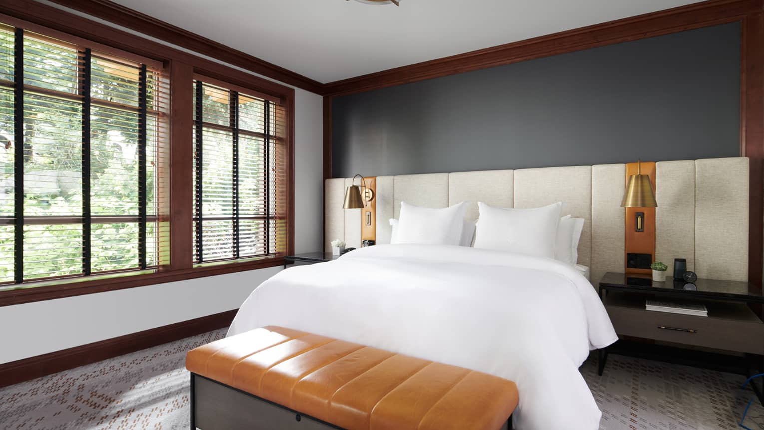 A luxurious bedroom at Four Seasons Resort Whistler, featuring a spacious king-sized bed with pristine white bedding. The room has dark gray walls, a high ceiling, and is framed by large windows with a wooded view, providing a serene, natural backdrop. A stylish leather bench sits at the foot of the bed, and elegant bedside lighting adds a warm ambiance. The refined decor reflects a modern yet cozy mountain retreat aesthetic.,A luxurious bedroom at Four Seasons Resort Whistler, featuring a spacious king-sized bed with pristine white bedding. The room has dark gray walls, a high ceiling, and is framed by large windows with a wooded view, providing a serene, natural backdrop. A stylish leather bench sits at the foot of the bed, and elegant bedside lighting adds a warm ambiance. The refined decor reflects a modern yet cozy mountain retreat aesthetic.