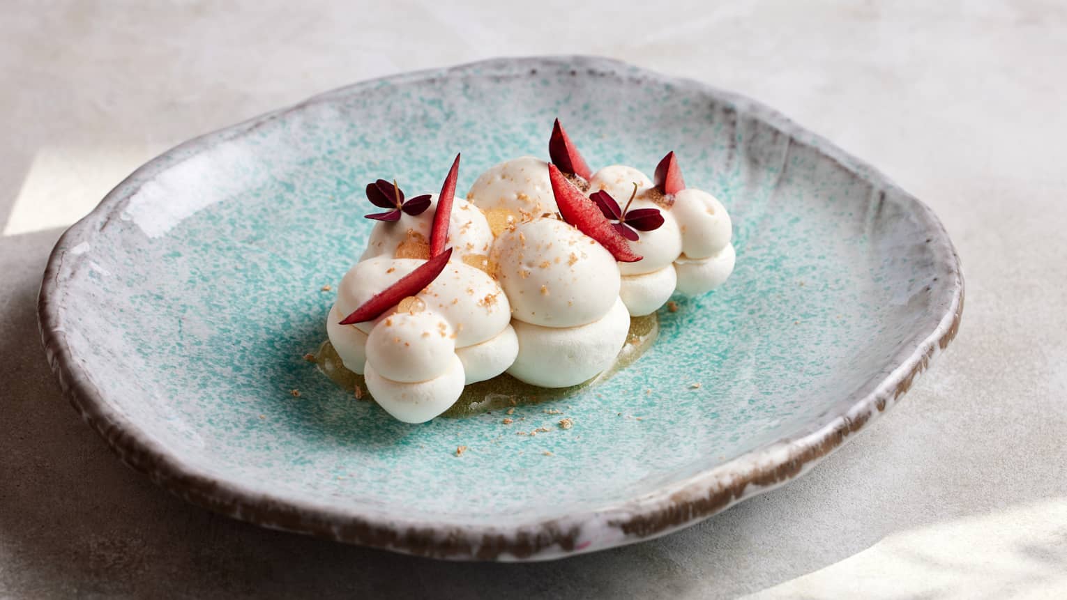 Cloud-shaped desert plated on a light-blue stoneware dish