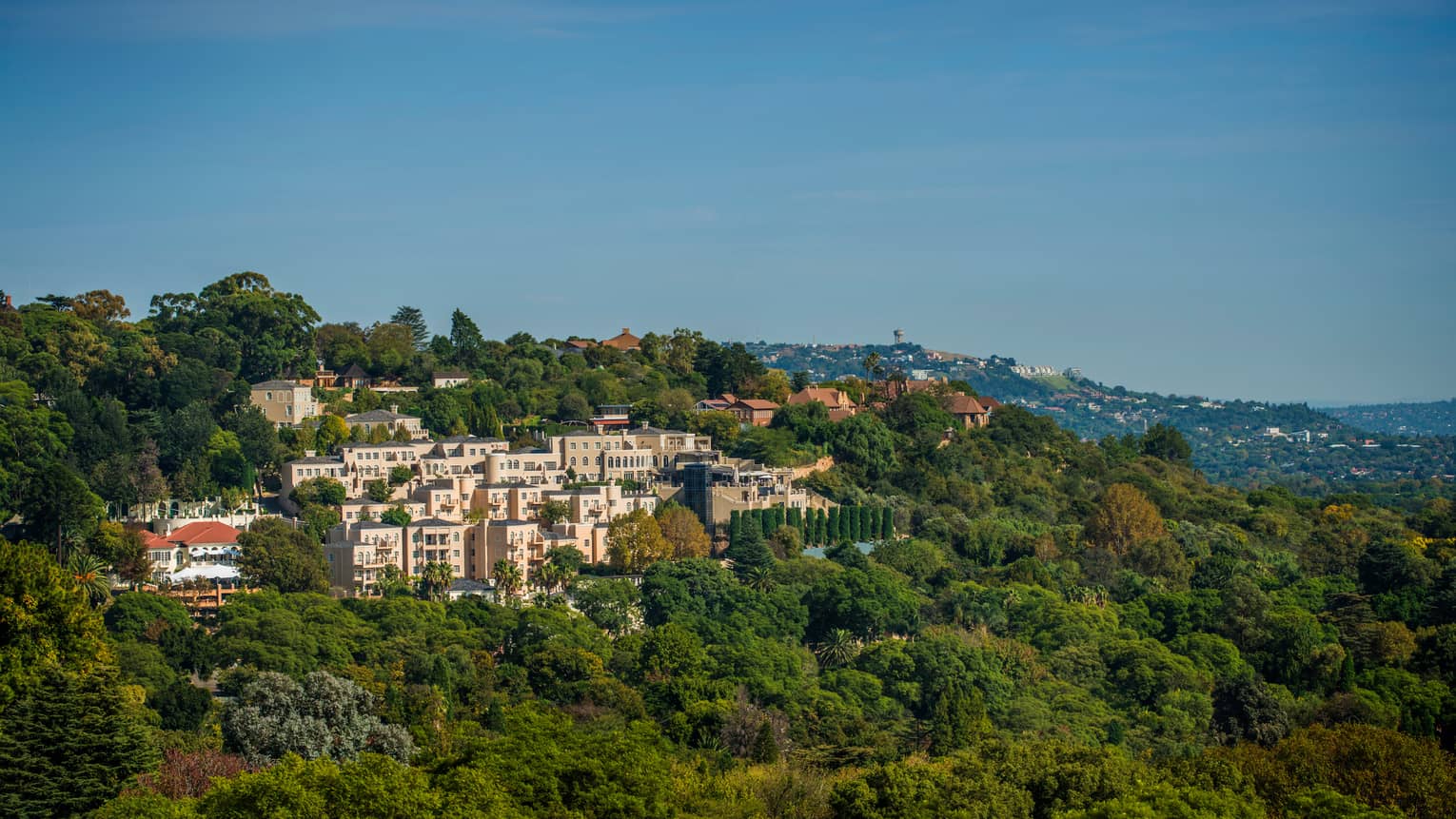 Aerial view of pink Four Seasons Hotel The Westcliff, Johannesburg building in green mountain
