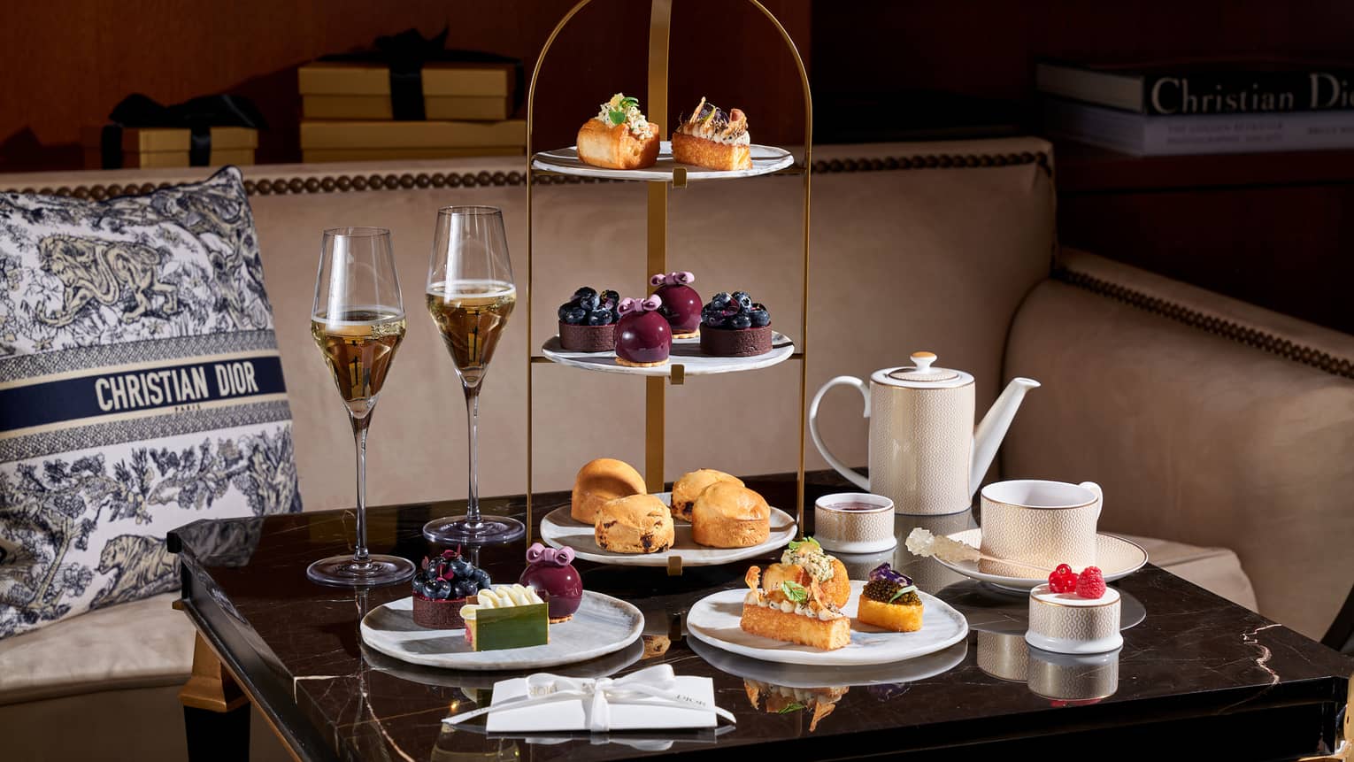 Christmas afternoon tea setup on square table beside banquette set with a black-and-white Christian Dior pillow