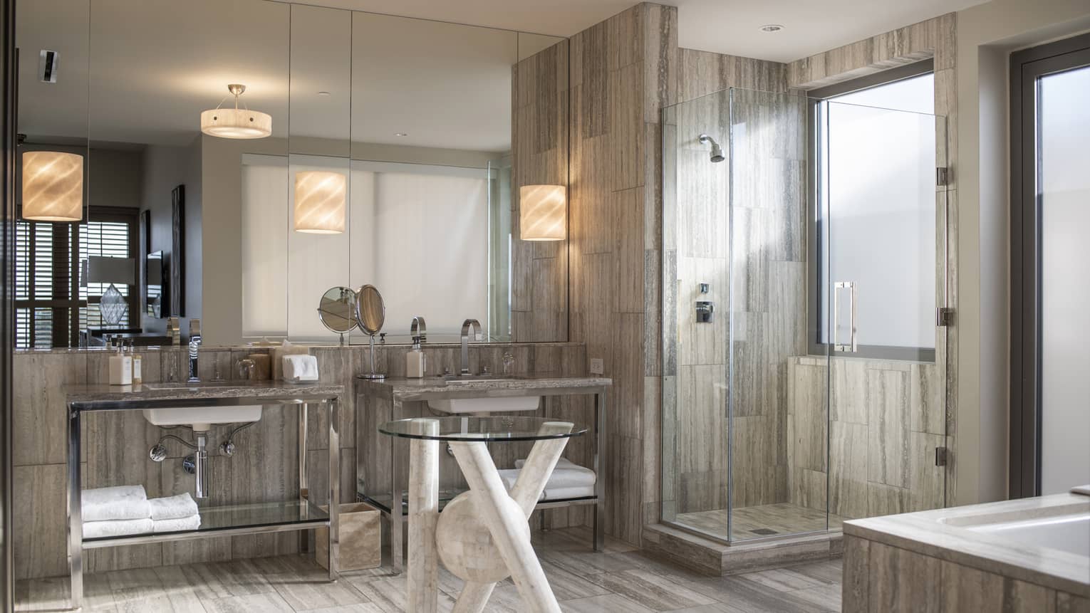 Modern bathroom with grey slate tiles, glass table, glass shower, two vanities