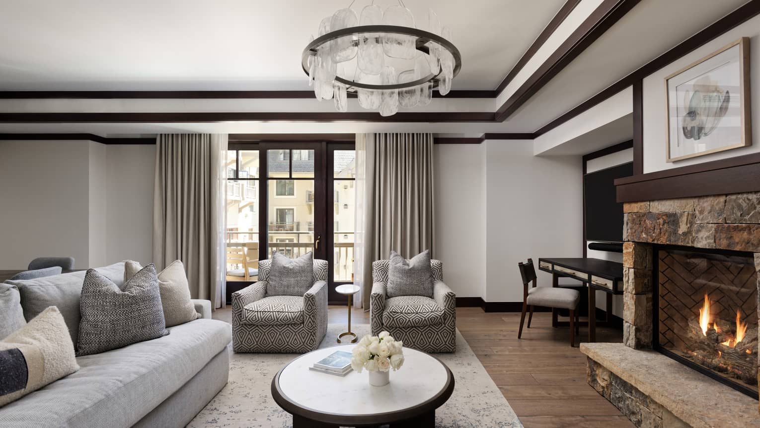 Living room with grey sofa, two arm chairs and stone fireplace