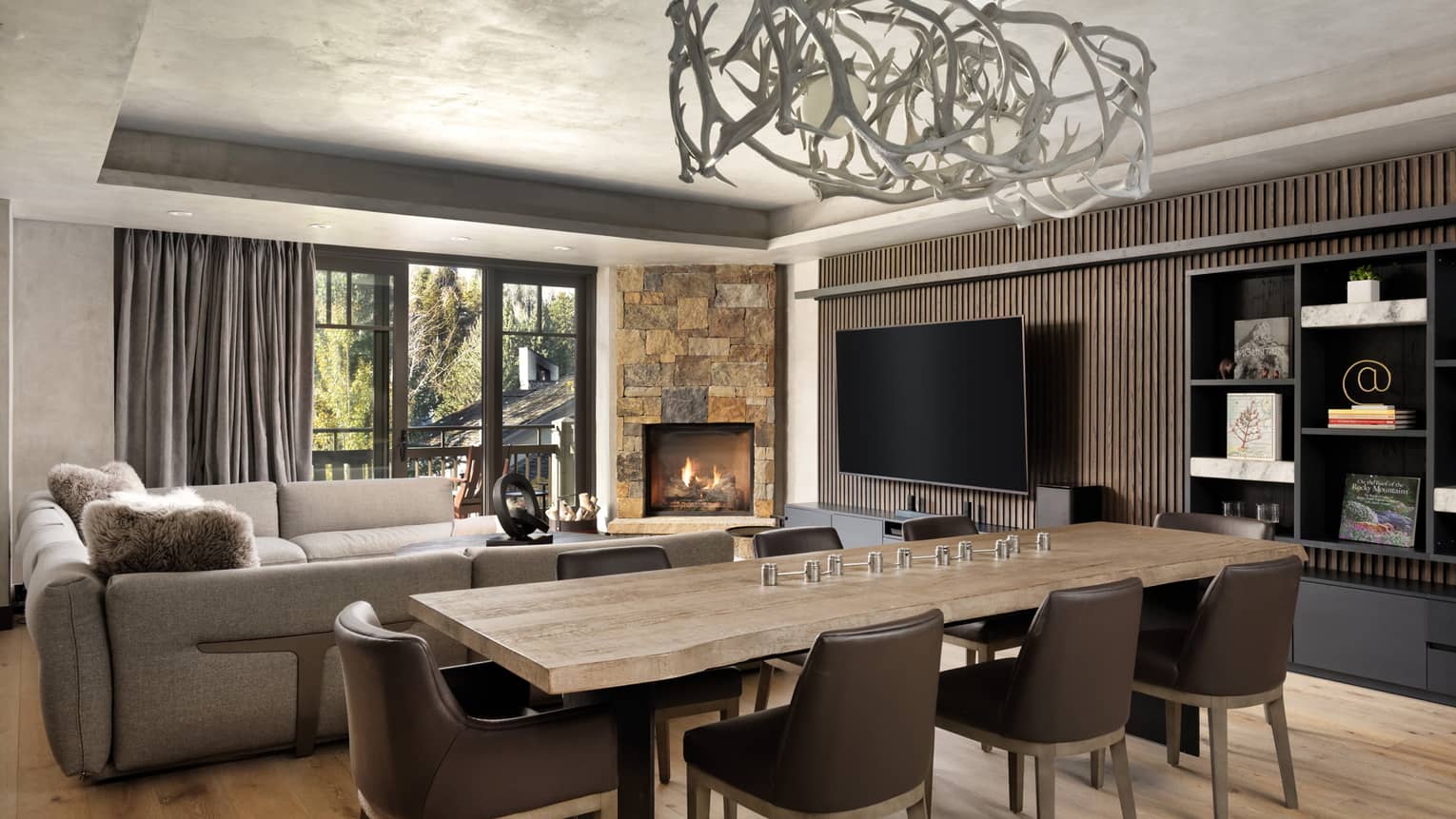 Wooden dining table with 8 brown leather chairs, abstract chandelier, living room