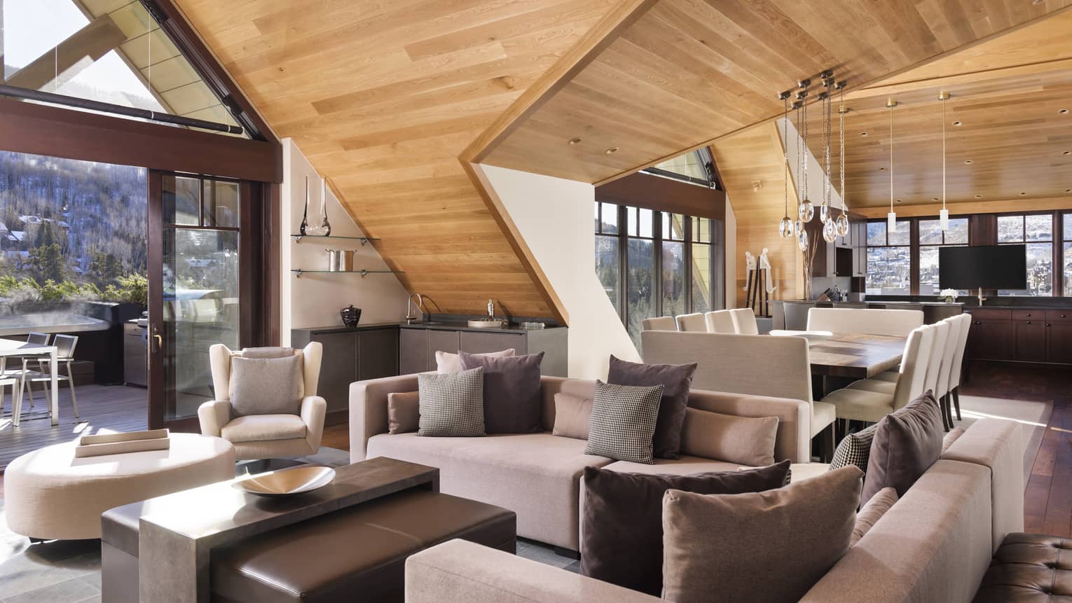 Living room with wooden vaulted ceilings, two sofas and ottoman-table