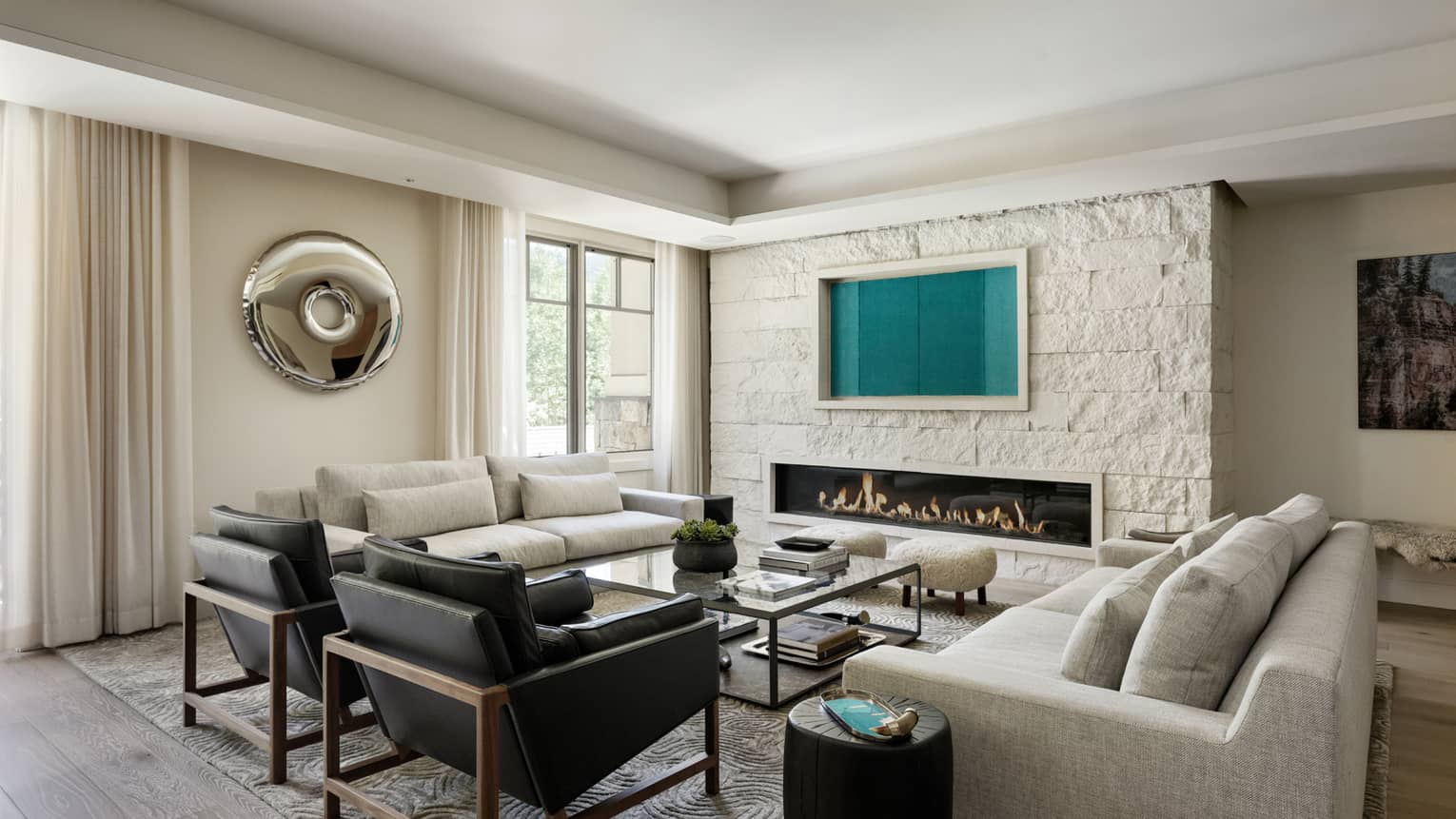 LIving room with two sofas, large square table, two black leather chairs, long built-in fireplace, Lover's Leap at Four Seasons Resort and Residences Vail