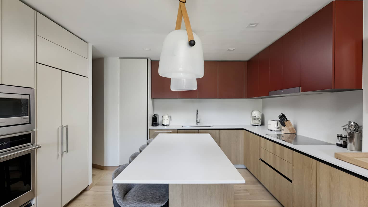Sleek, minimalistic kitchen of a Four Seasons Vail residence with island featuring four counter chairs