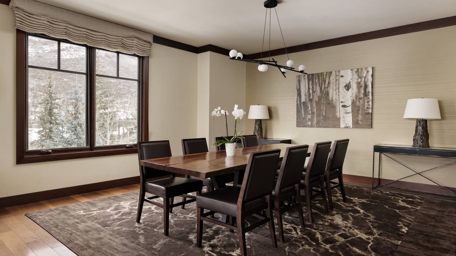 Dining room with table for eight and window with snowy mountain view