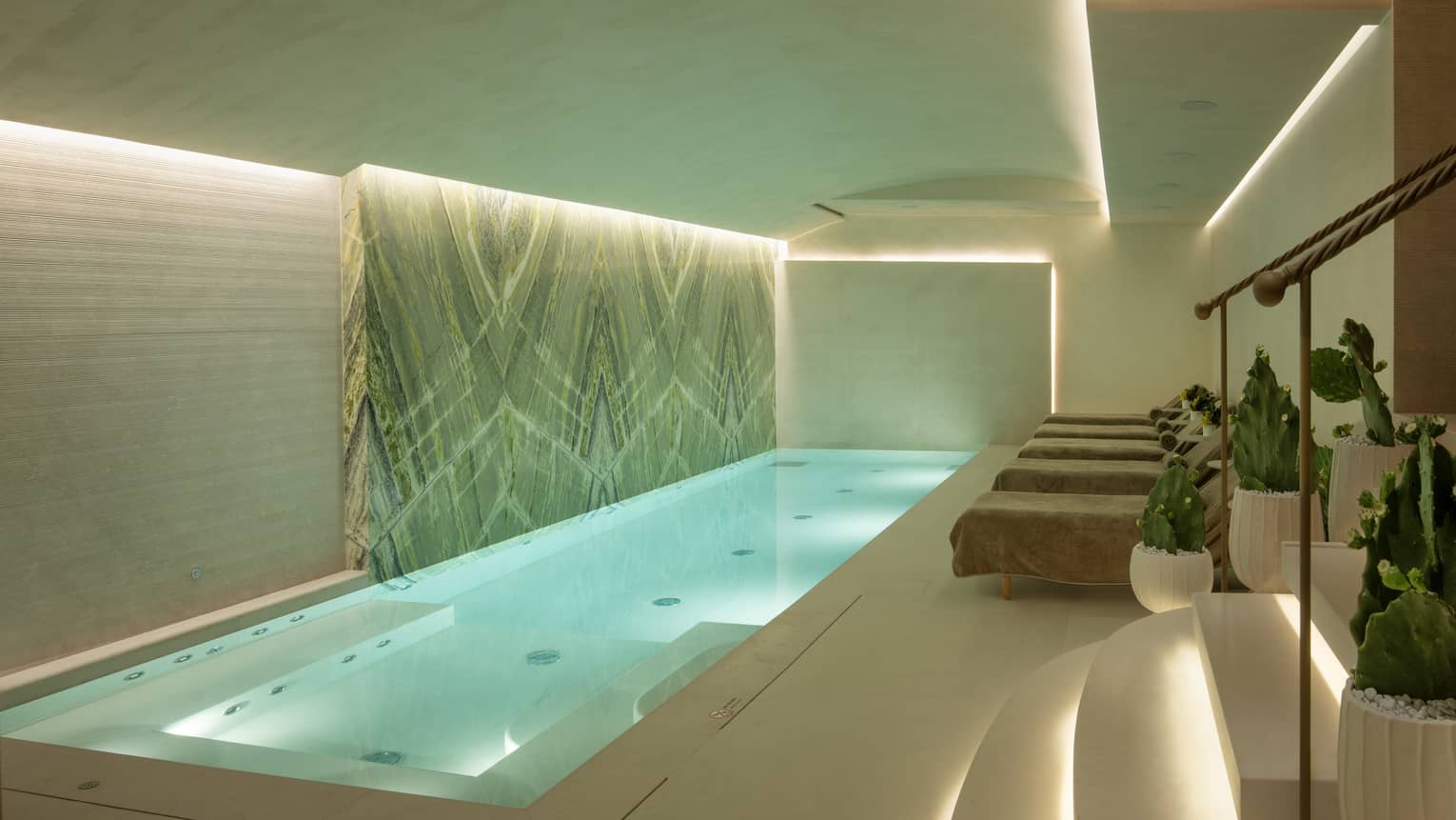 Indoor spa pool with uplit ceiling and steps