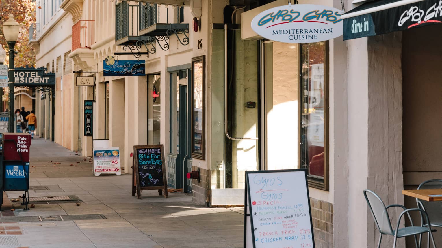 Shops along a sidewalk with signs at each door.