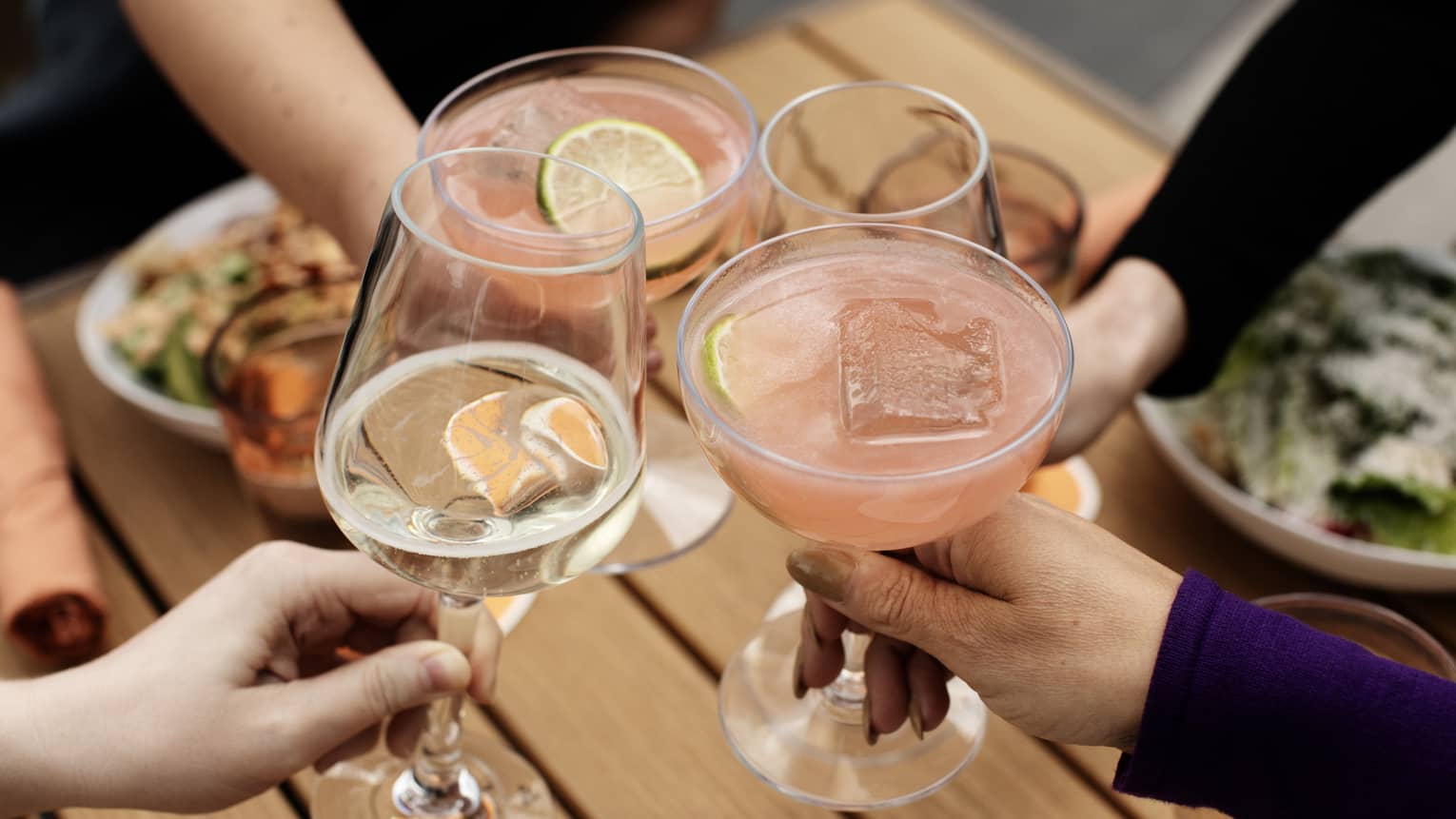 A group of people toasting with wine and cocktails.