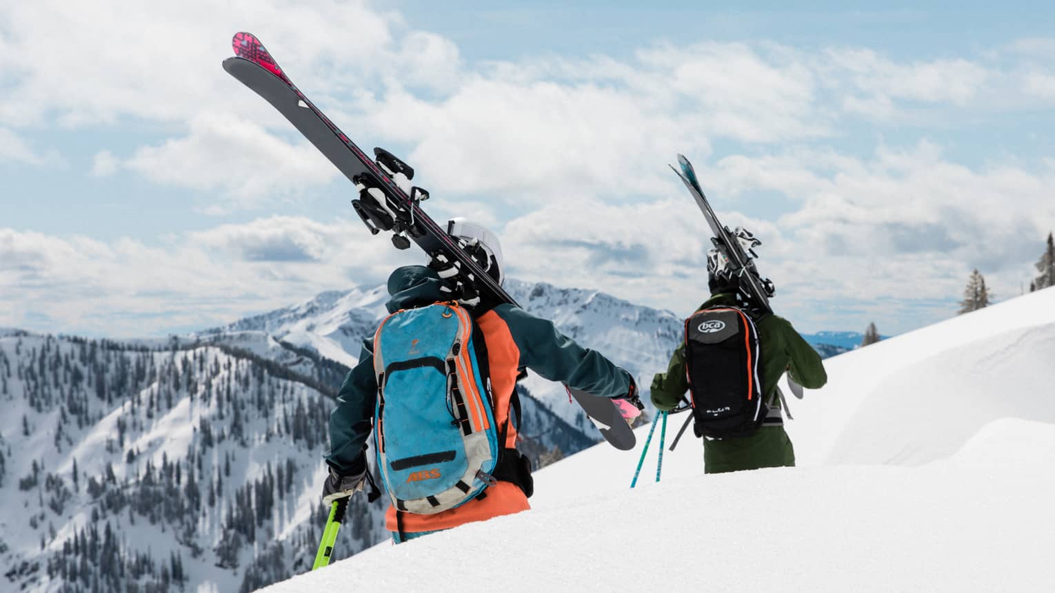 Two people in ski gear walking along a ski trail