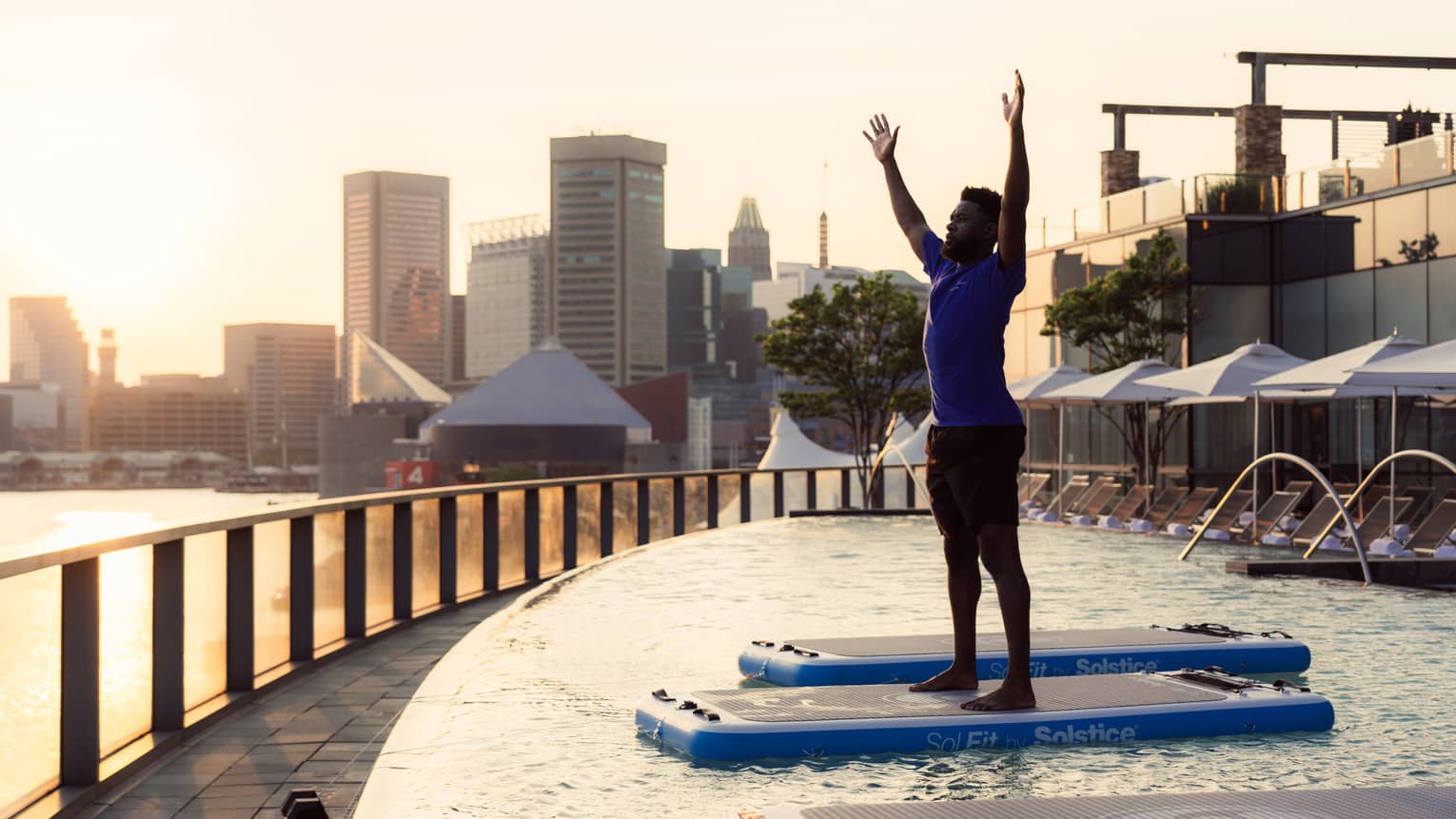 Guest standing in a pool doing pool yoga.