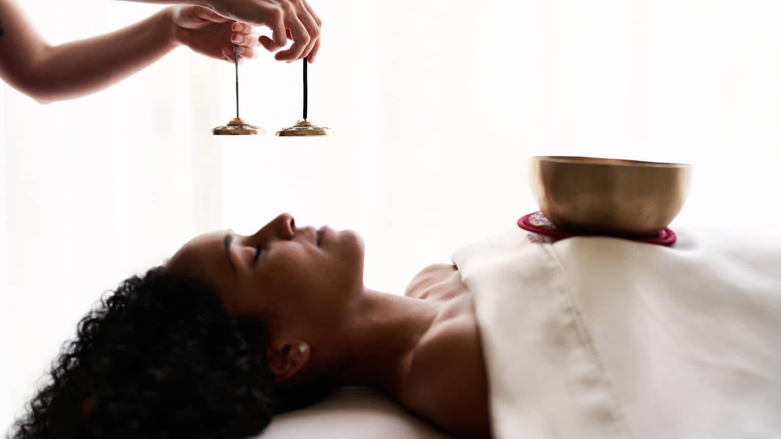 A woman experiencing vibrational sound therapy.