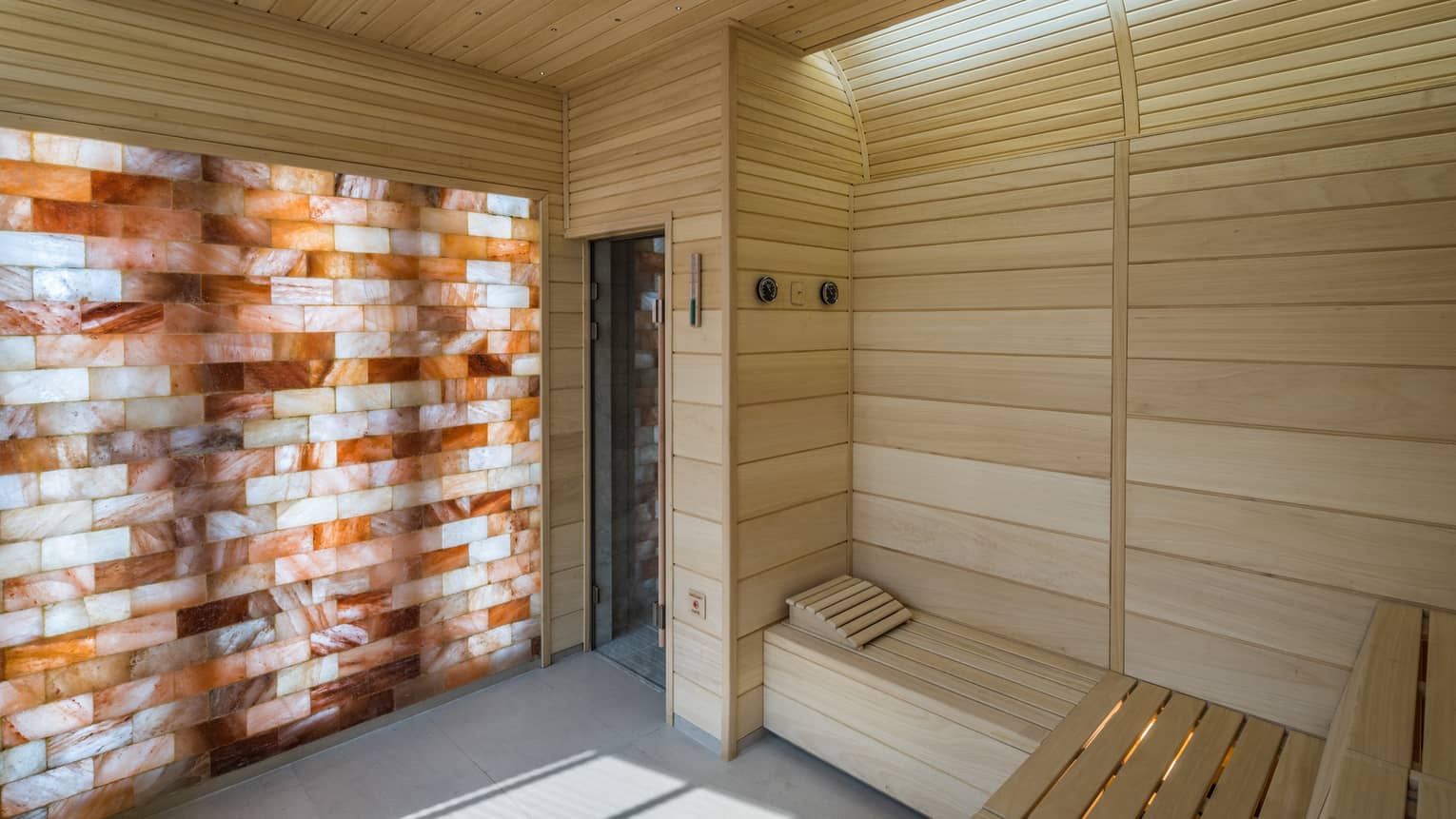 The Club wood sauna room with illuminated wall with wood, brick pattern