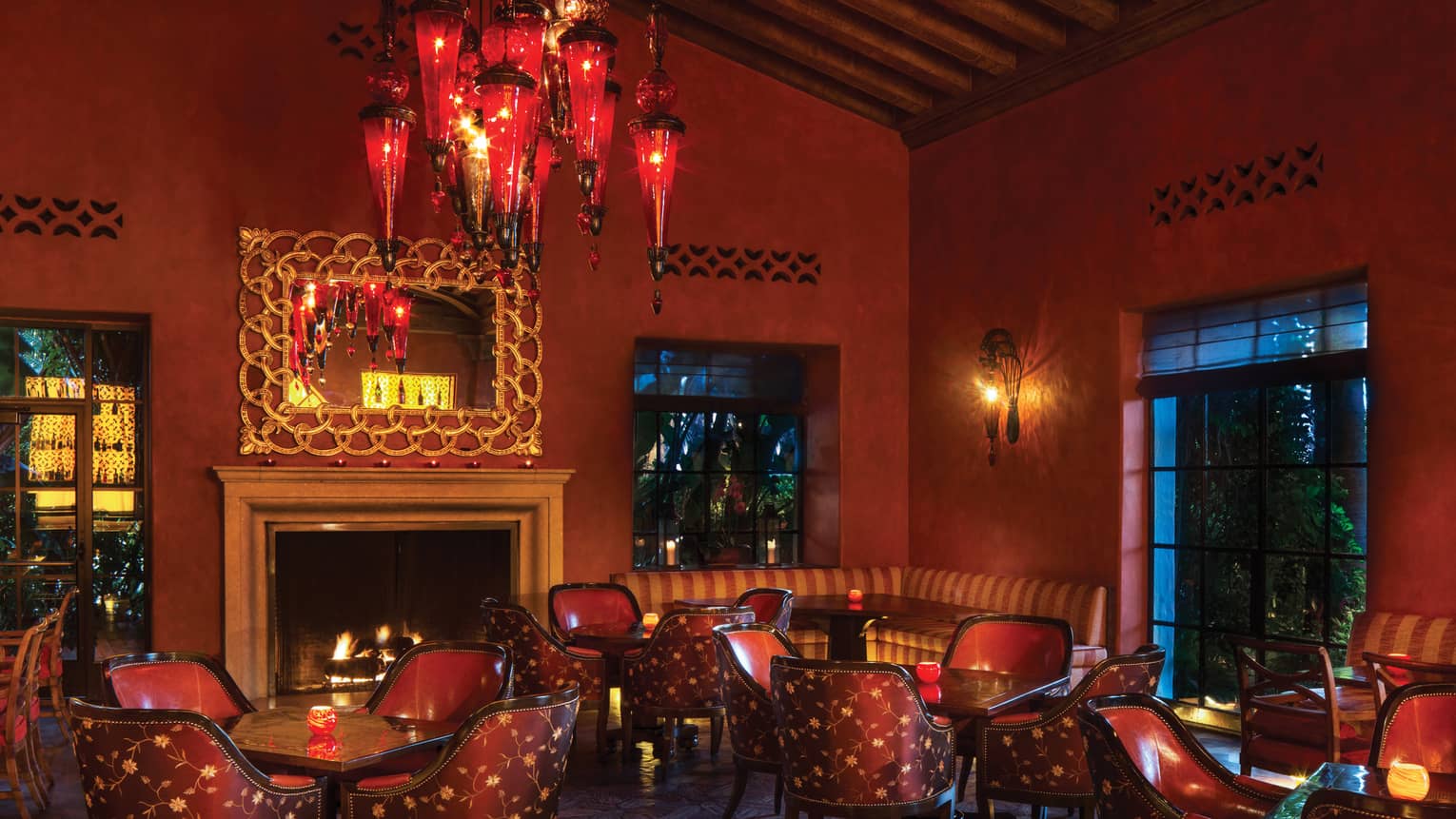 Ty Lounge with red floral cocktail lounge chairs around table under red glass lanterns