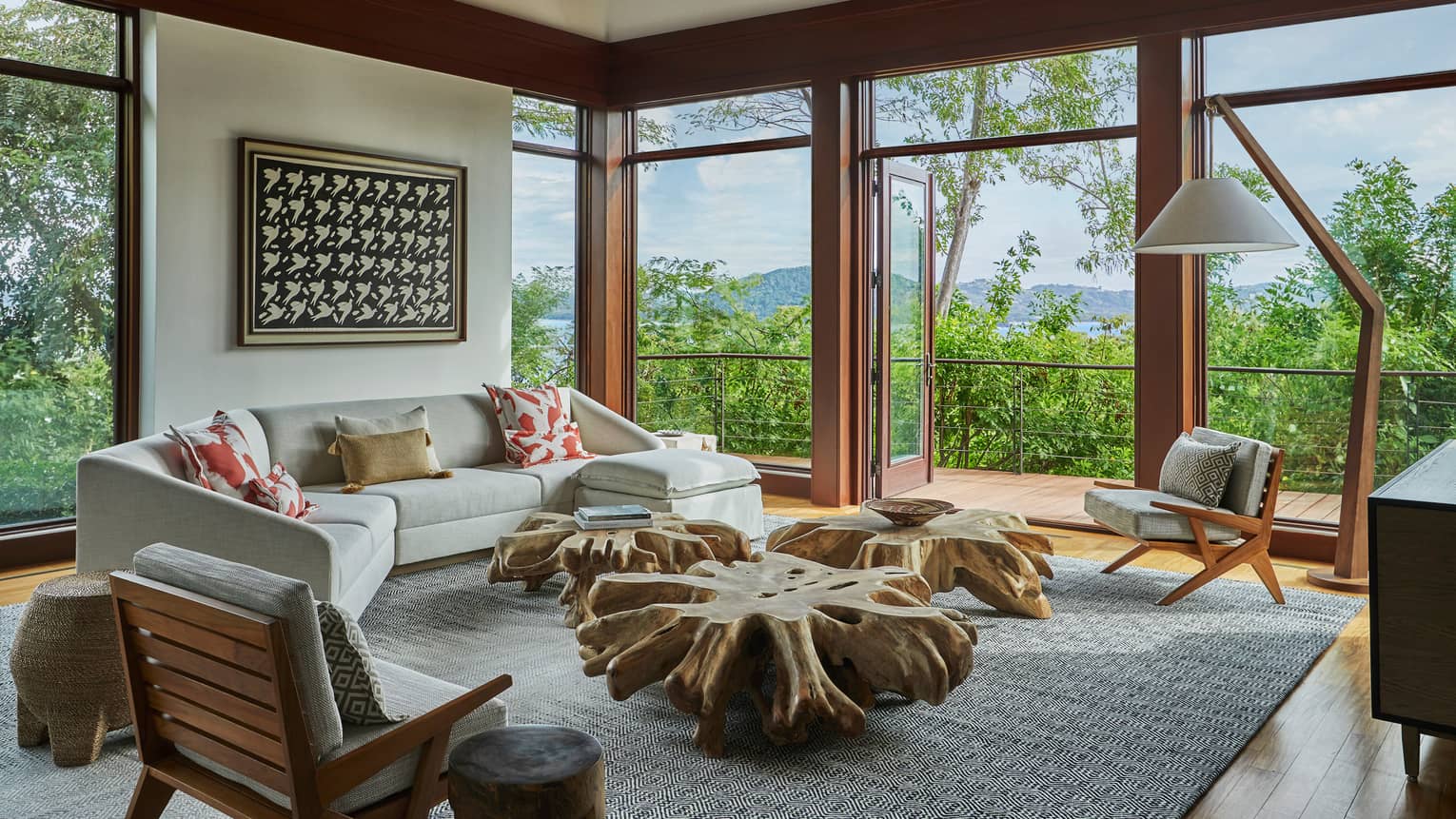 Miramar Suite curved sofa, modern armchairs around rustic reclaimed wood tables, corner picture windows