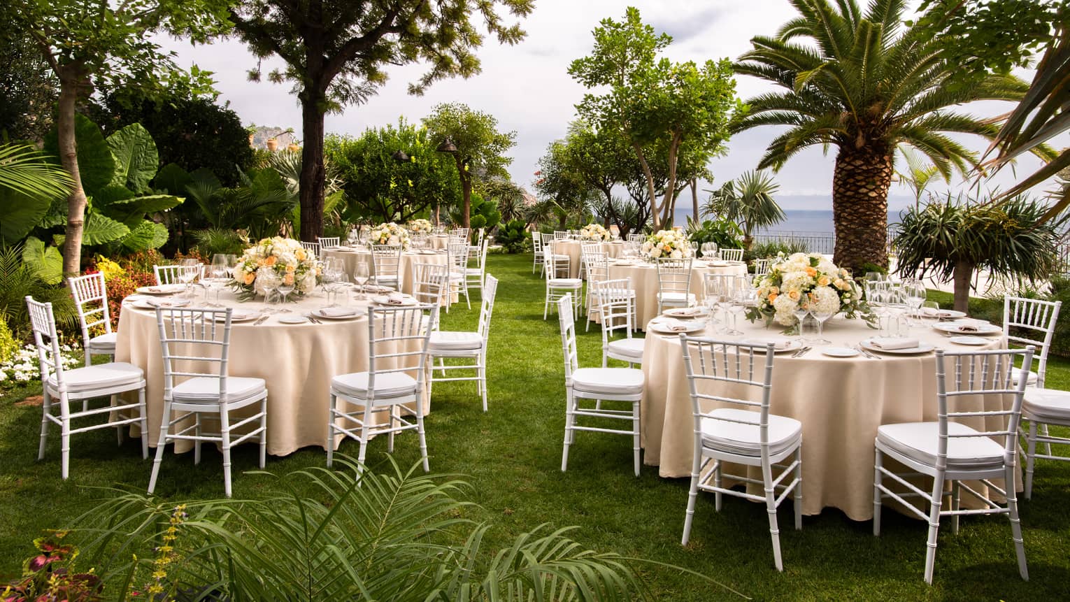 Outdoor wedding banquet with palm trees, sea view