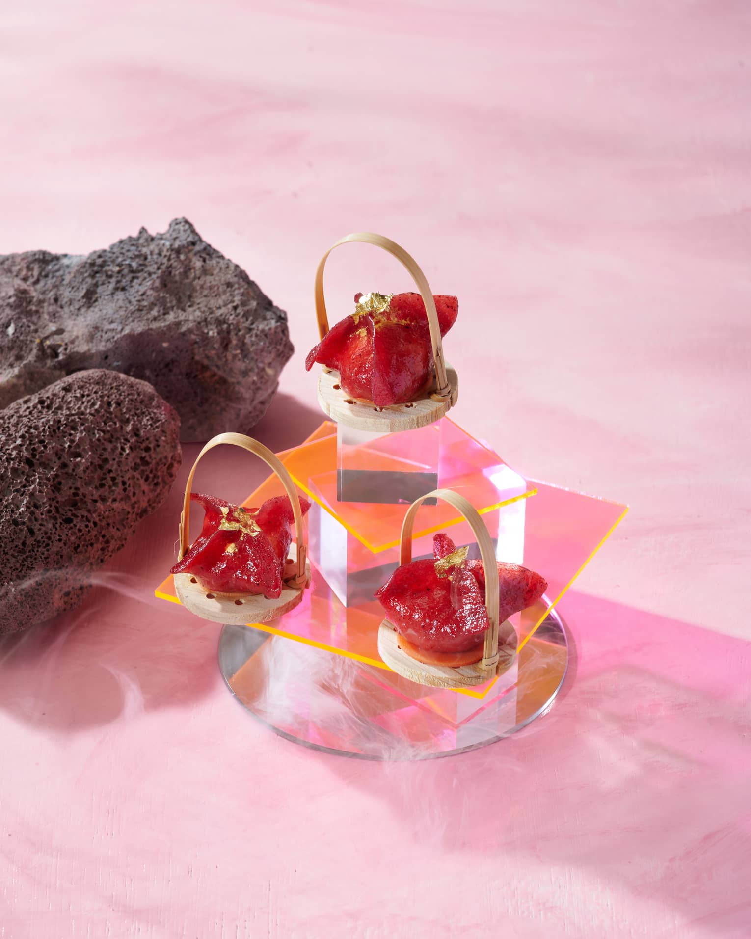Tiered glass display of small red-hued dumplings