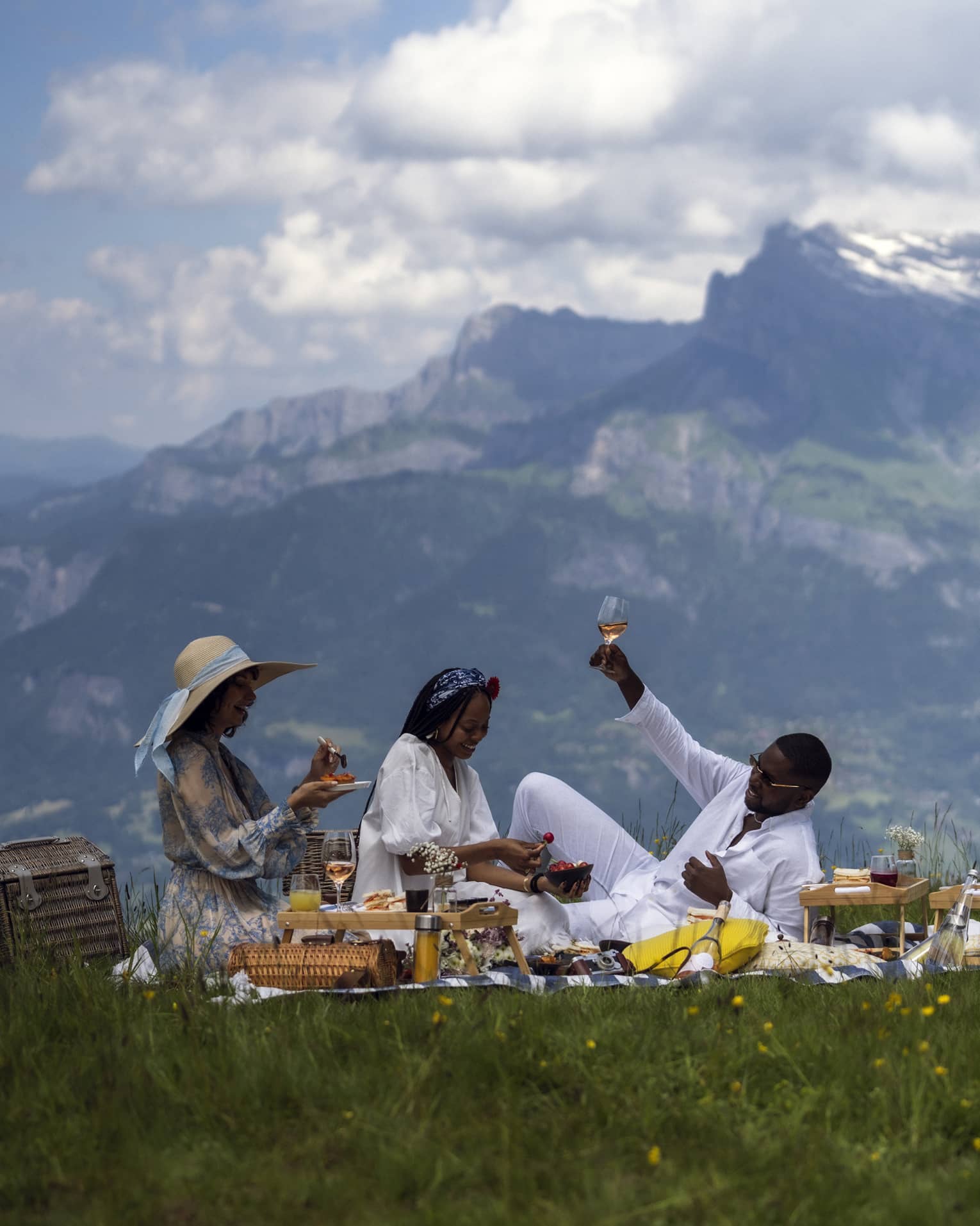 Three people enjoy gourmet picnic with ros� in French Alps