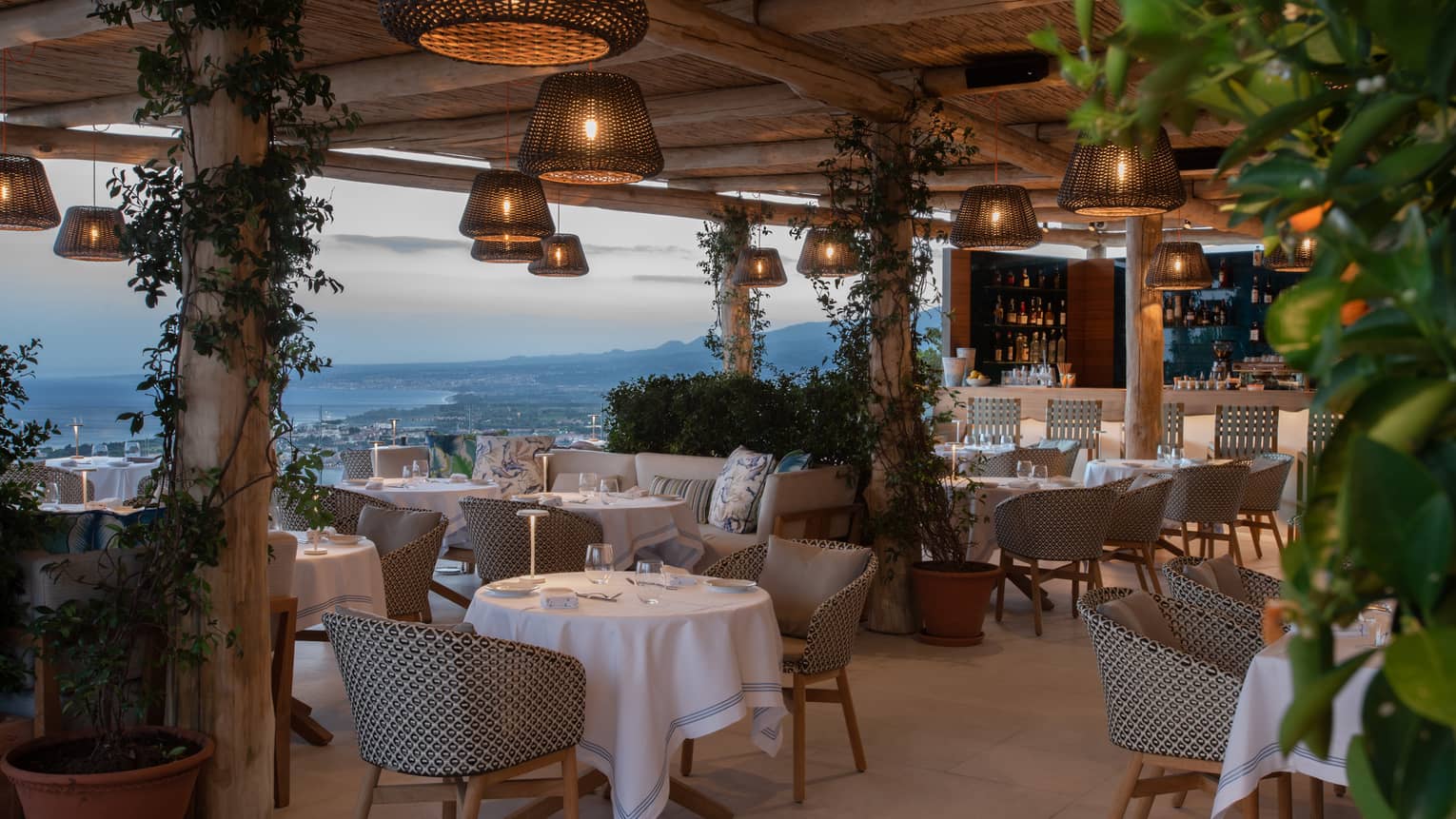 Outdoor terrace restaurant with hanging whicker lights, sea view