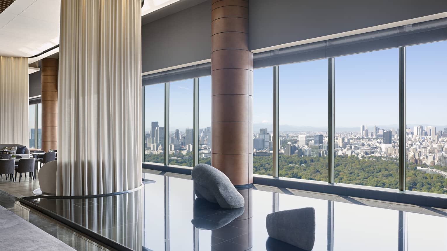 Hotel lounge featuring a calming indoor pond installation and wall of windows