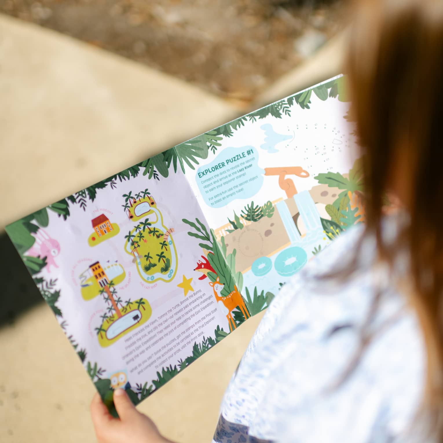 A young guest reading a picture book outside