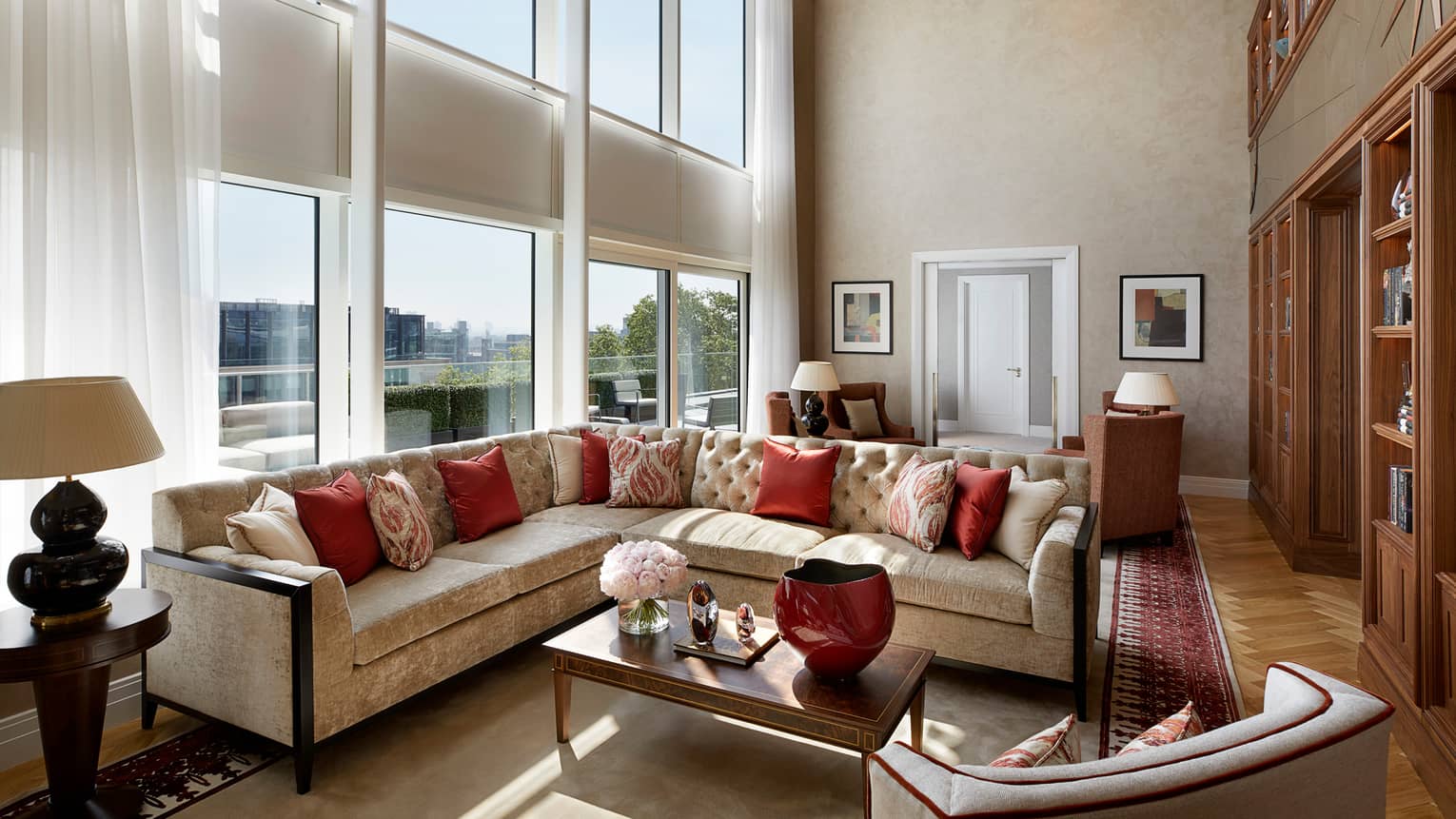 Large L-shaped velvet sofa, living room under sunny, two-storey floor-to-ceiling window