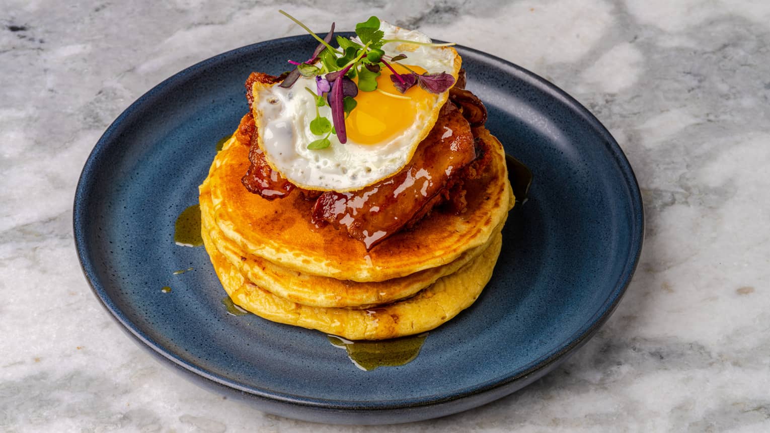 A stack of pancakes on a plate with syrup