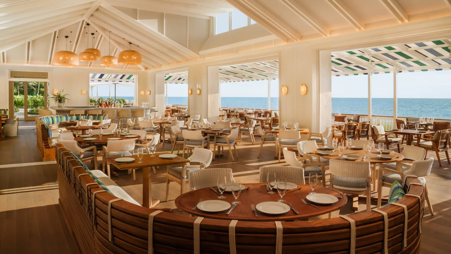 Brighty lit dining room with indoor and outdoor seating and an ocean view