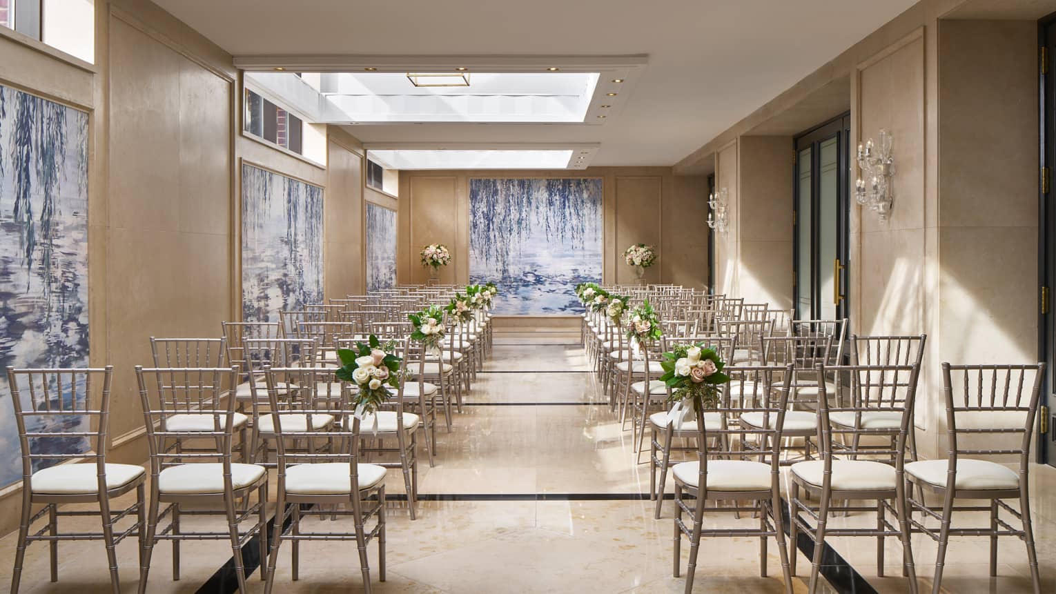 Rows of chairs under the ample skylights of Dumbarton Conservatory, decorated with wedding flowers.