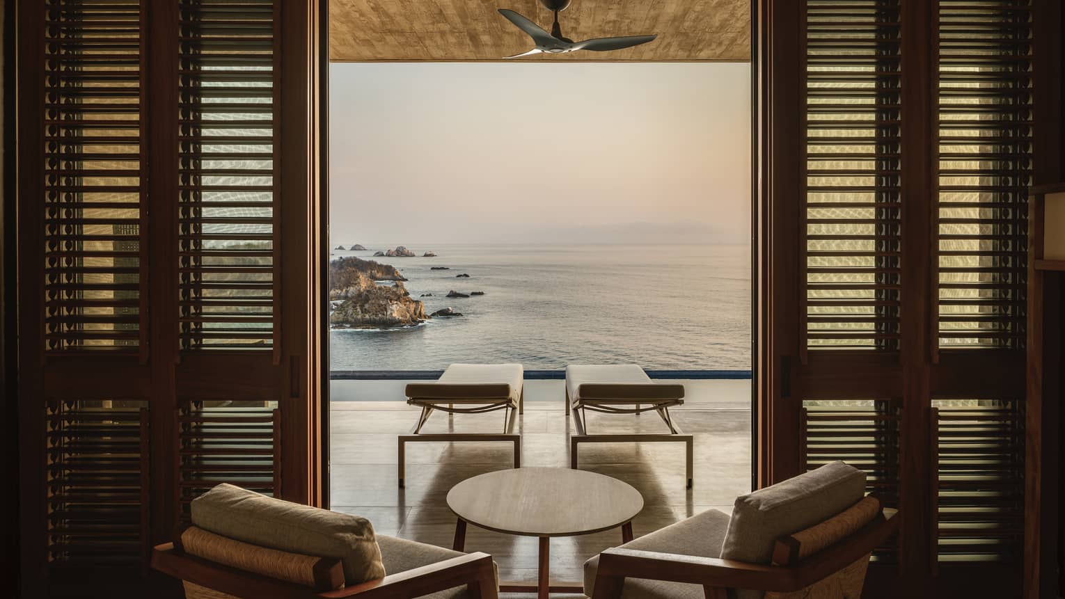 Room with an outdoor balcony overlooking the ocean.