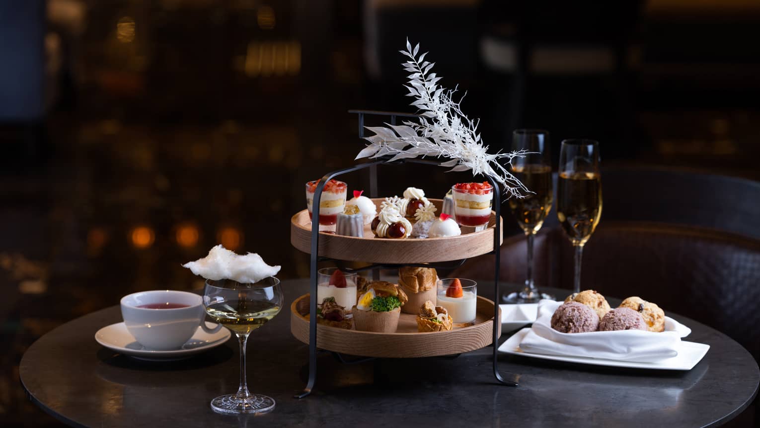 White Christmas Afternoon Tea two-tier display with sweets, two glasses of champagne and coffee